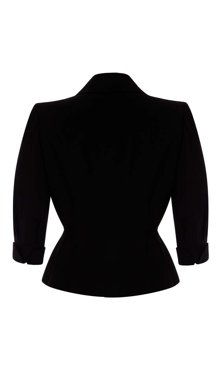 Gorgeous and quirky 1940’s black textured silk jacket from American label Leslie Faye. Featuring ¾ sleeves, nipped in waist and unusual button down collar. It fastens at the front with elaborate black buttons and a larger version of the same at the