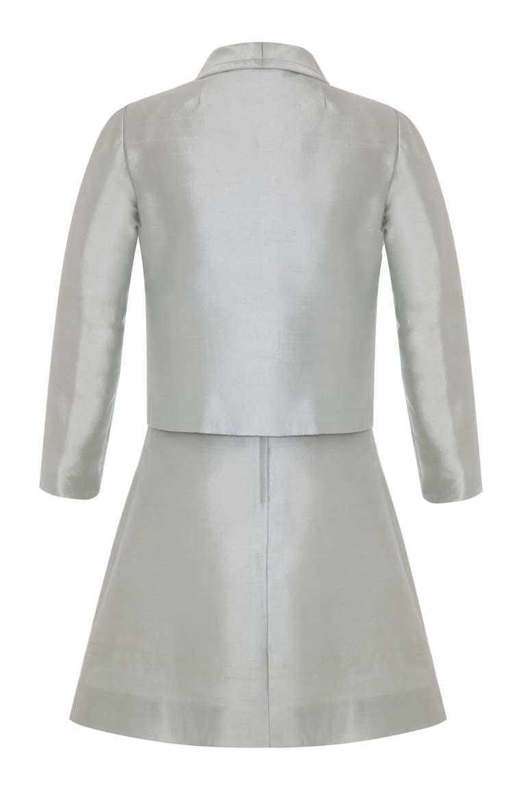 Beautiful pale blue silk suit from French designer and artist Louis Feraud. This cute 60’s 2 piece consists of a two tone A-line mini dress with blue skirt and cream bodice and matching blue jacket. Unusual stitching details and covered buttons in