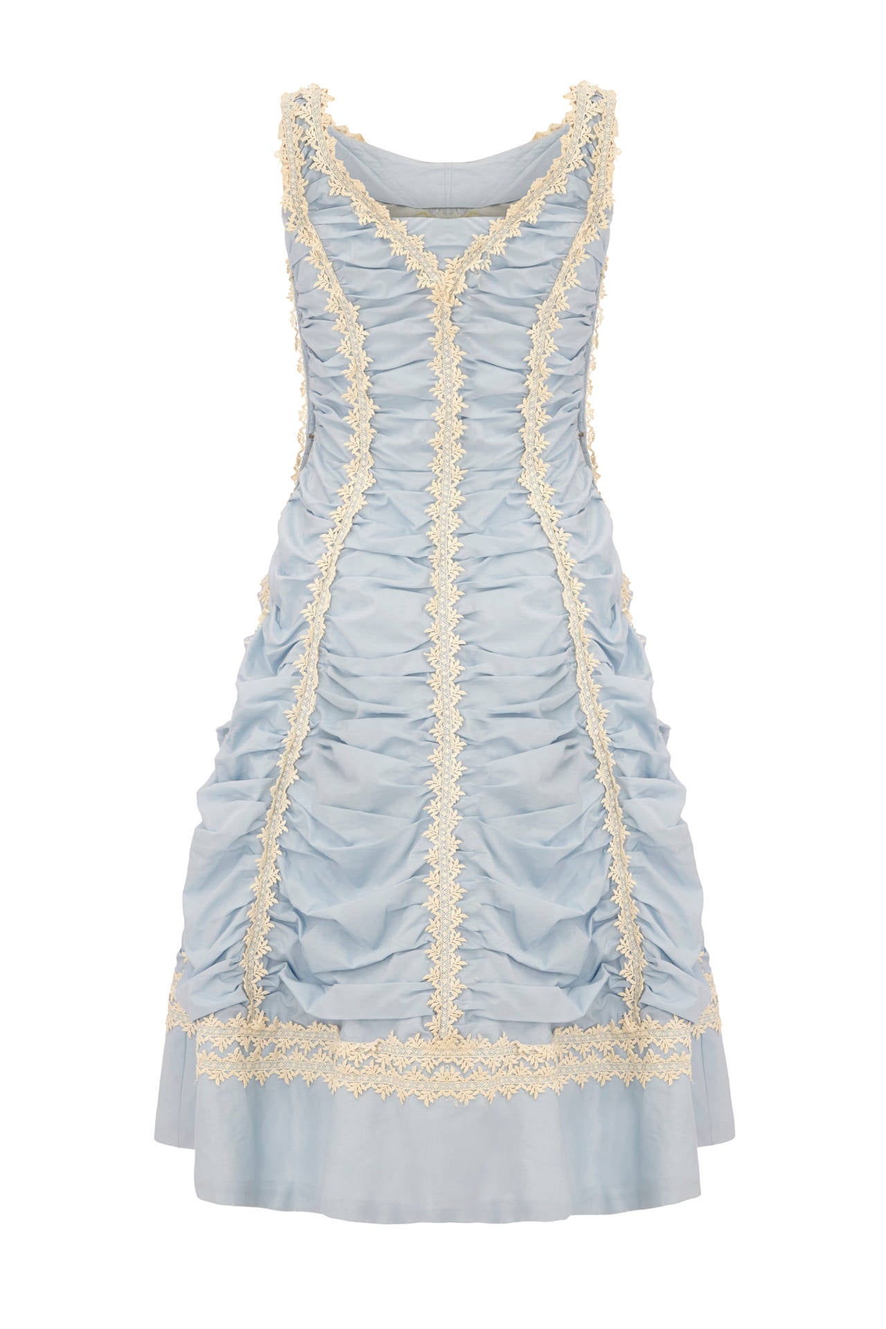 Very unusual pale blue cotton dress with heavy ruching throughout and white lace crochet applique forming panels.  This American piece is lined in pale blue organza, fastens at the side with a zip and has a net petticoat attached giving the skirt