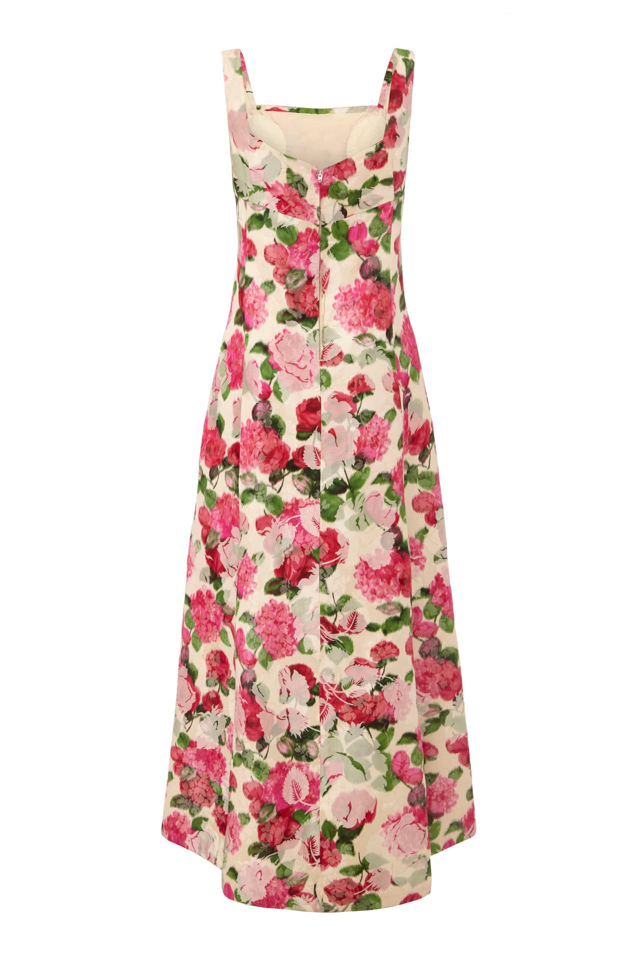 Amazing full length, sleeveless custom gown in beautiful pink, cream and green floral brocade. This piece features an empire line and padding in the bust with netting in the skirt for a bit of extra volume.  It is lined in ivory, fastens at the back