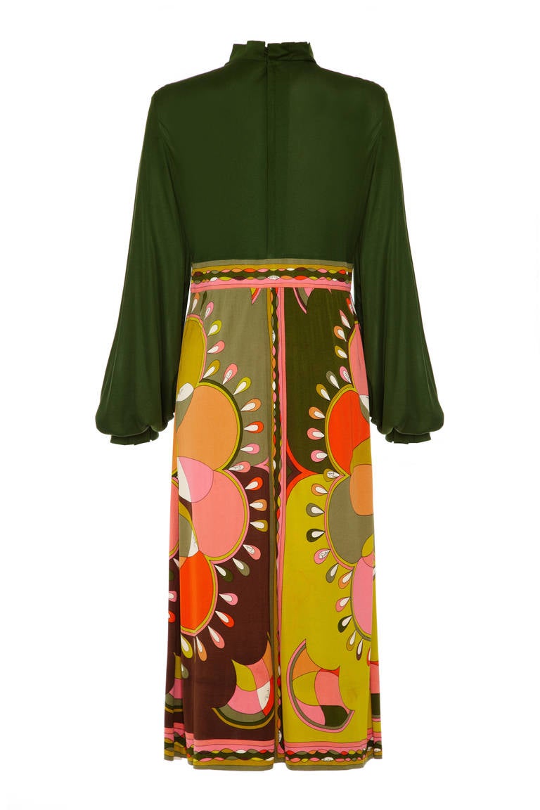 Amazing moss green silk jersey dress from Emilio Pucci with beautiful multi-coloured printed skirt.  The dress features long sleeves and a high neckline with pretty pleated edging, which is mirrored around the cuffs. The dress fastens with two zips,