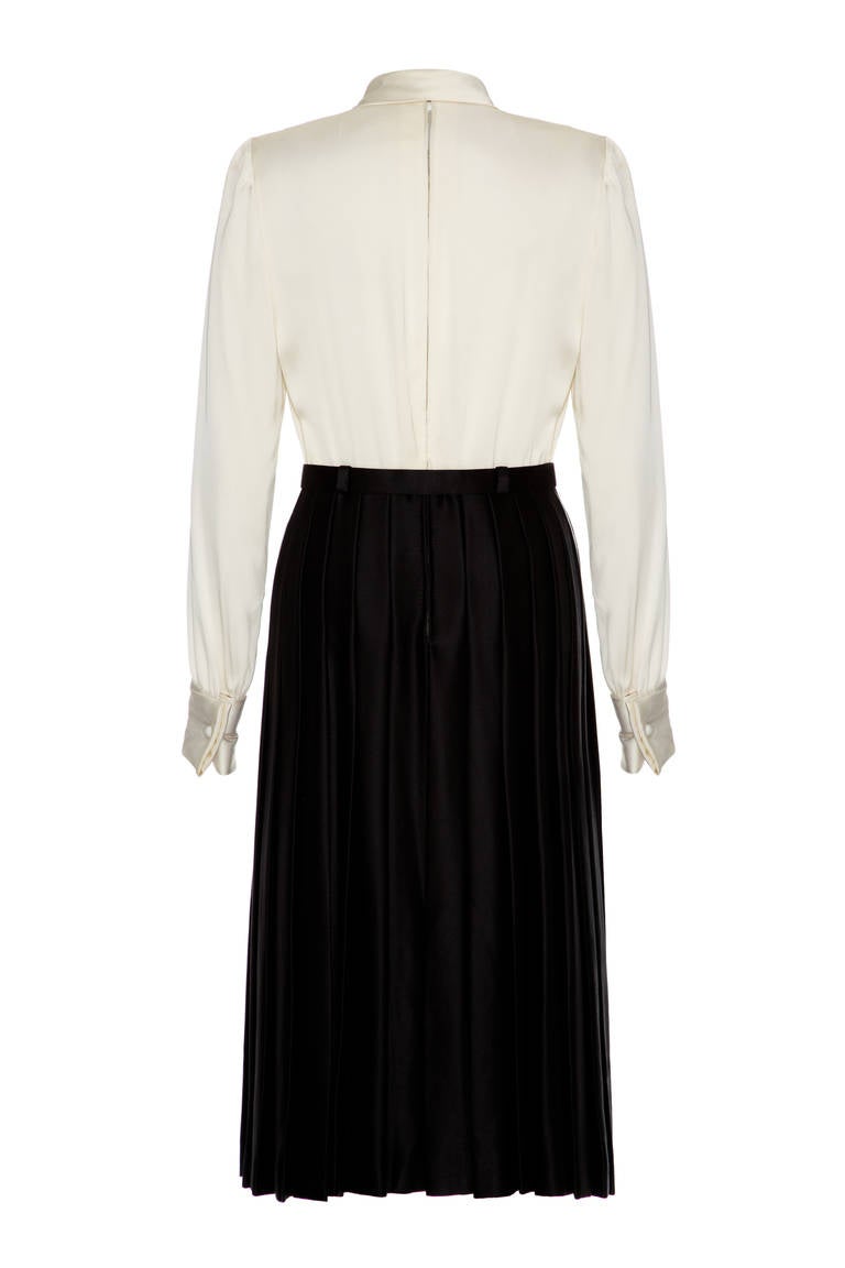 Simply stunning and elegantly simple long sleeved, knee length haute couture Lanvin silk dress.  This piece consists of cream silk bodice with attached necktie and black silk skirt with pleats through the back. It comes with original matching black