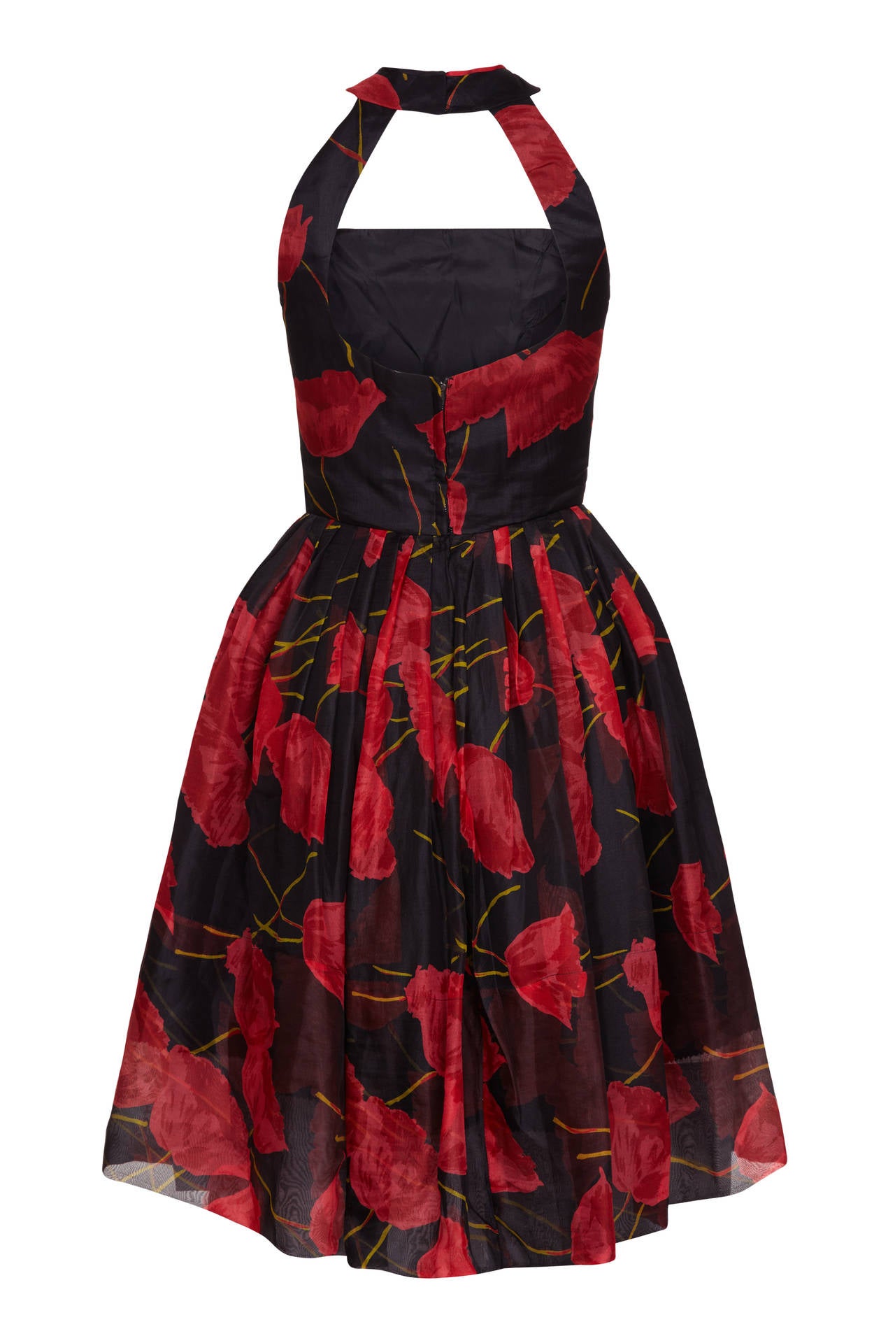 A Fabulous and unusual 1950s party dress in black silk organza with a bold and beautiful red tulip print. Two straps, which are not visible from the front, connect the back of the bodice to the collar piece, which sits around neck.  It is fully