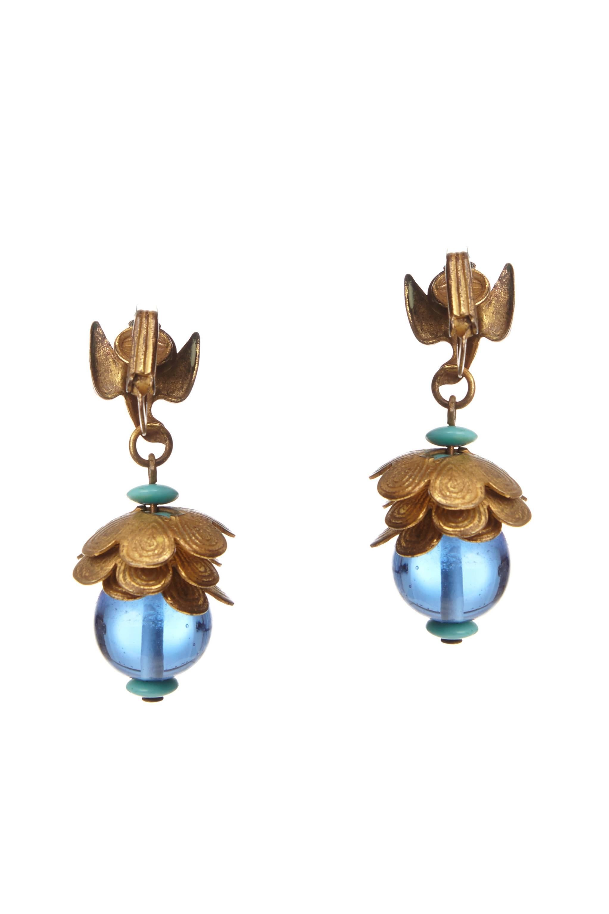 Gorgeous vintage gold tone metal clip-on earrings with blue glass beads by Miriam Haskell.  They were designed during the period of Larry Vrba's reign as the head designer and several similar peices can be seen in Cathy Gordon's book. This lovely