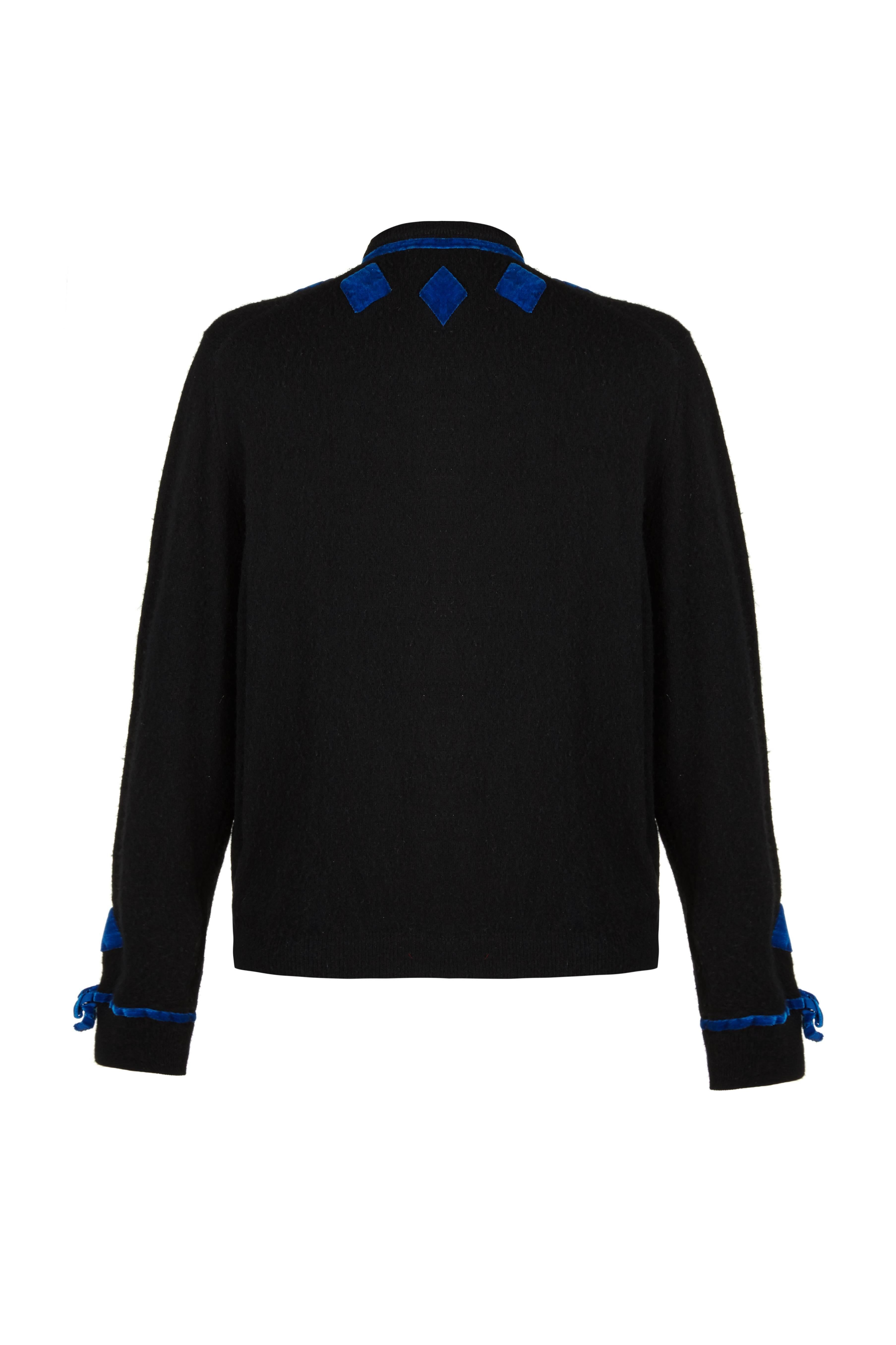 Cute vintage 1950s black cashmere cardigan with fun blue velvet appliqué around the neck, down the front and at the cuffs. There are matching blue velvet covered buttons to fasten down the front. Labeled Connaught, it is in excellent condition with