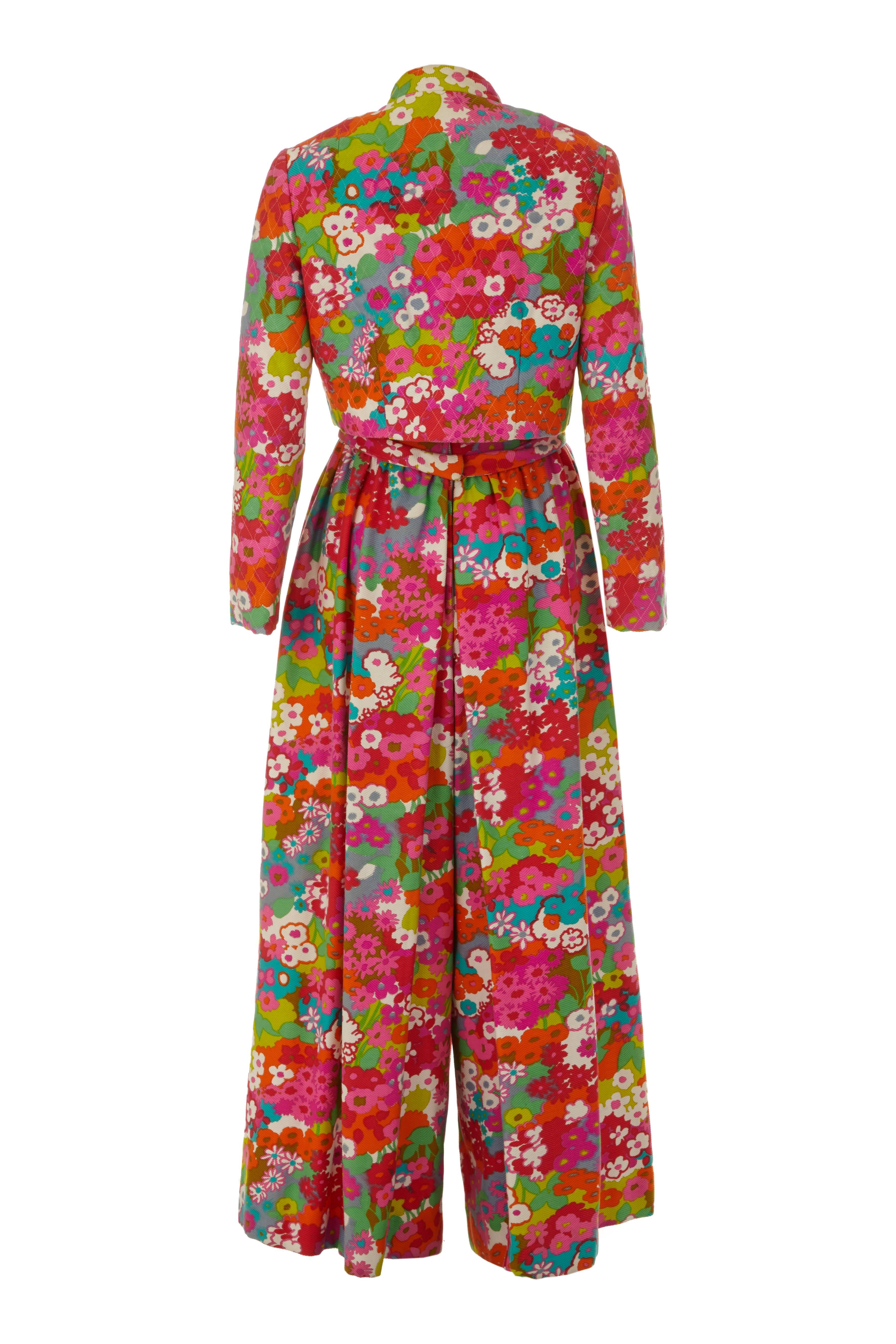 Bright and bold late 1960s vintage, thick cotton sleeveless jumpsuit with multicoloured floral print and matching long sleeved, lightly quilted jacket.  This is a really stand out outfit with low neckline, bow belt and long wide trousers.  The