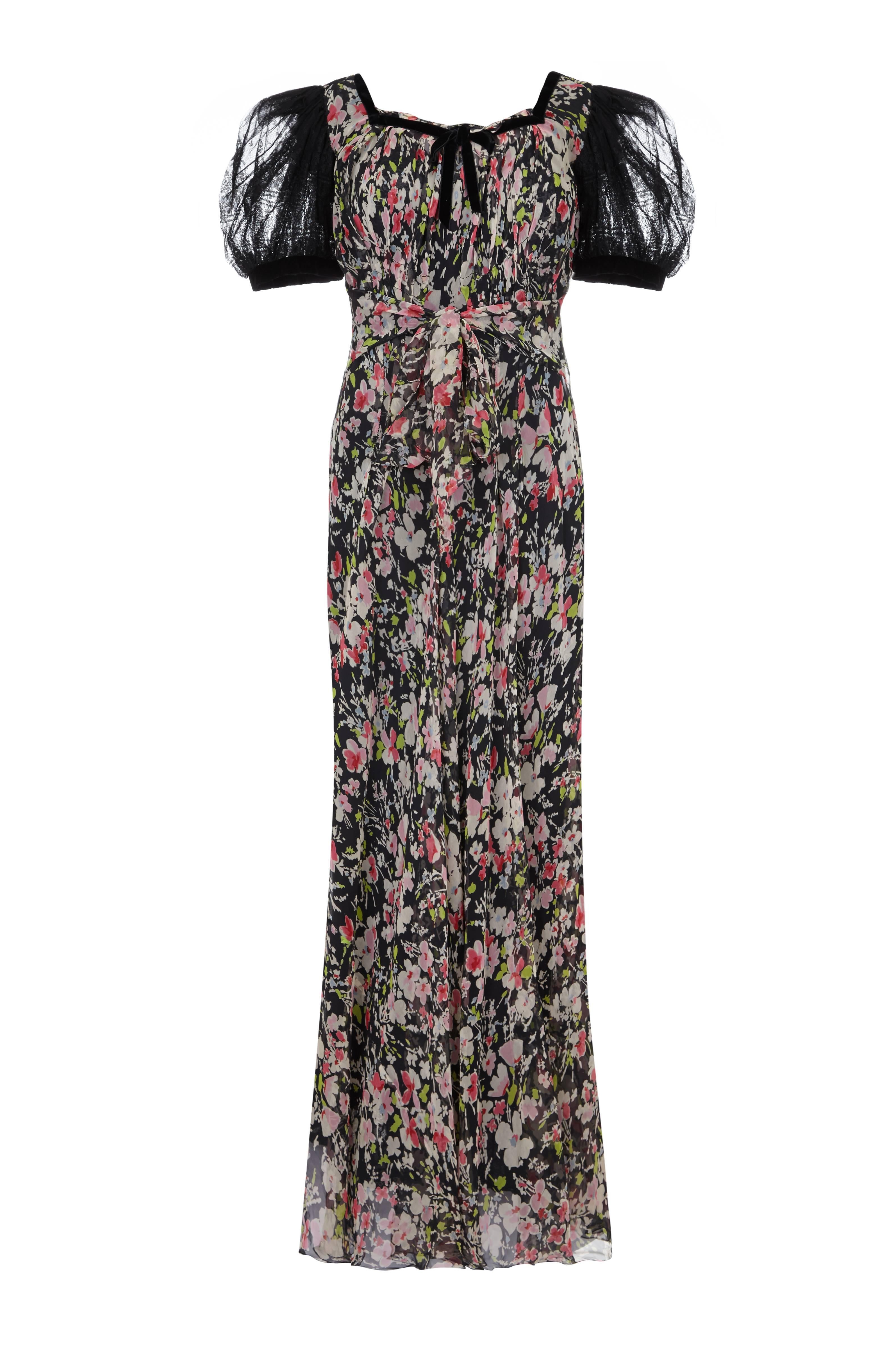 Beautiful vintage 1930s floral silk chiffon full-length dress with oversized black lace puff sleeves. This piece features black velvet trim and an attached waist tie belt.  Due to the sheer nature of the fabric the dress needs to be worn with a