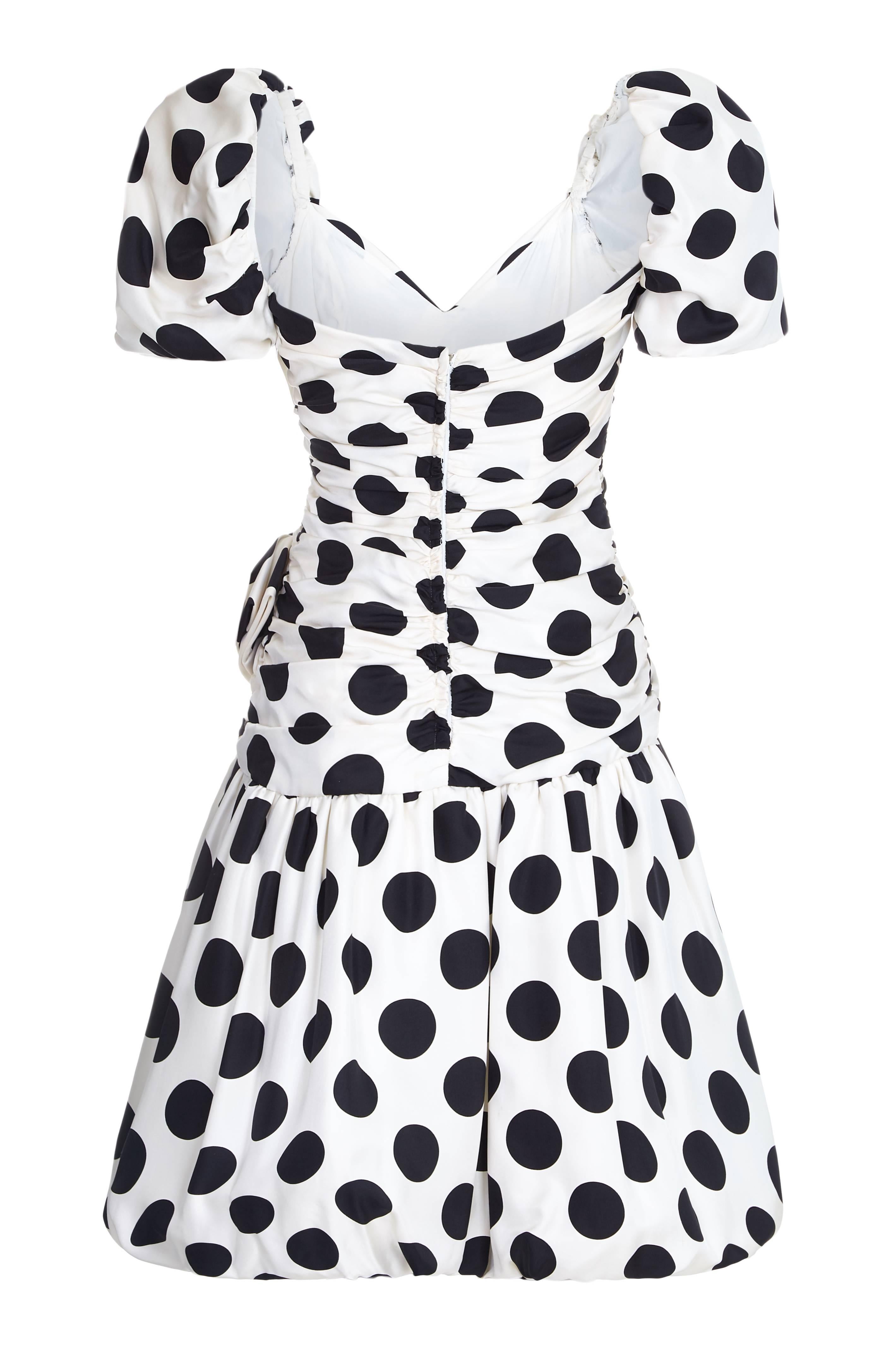 Very cute vintage 1980s dress by Lillie Rubin in black and white silk with polka dot print.  The dress features an asymmetrically ruched bodice with large bow on the left hip and a puffball skirt. Inside it is fully lined and there is some light