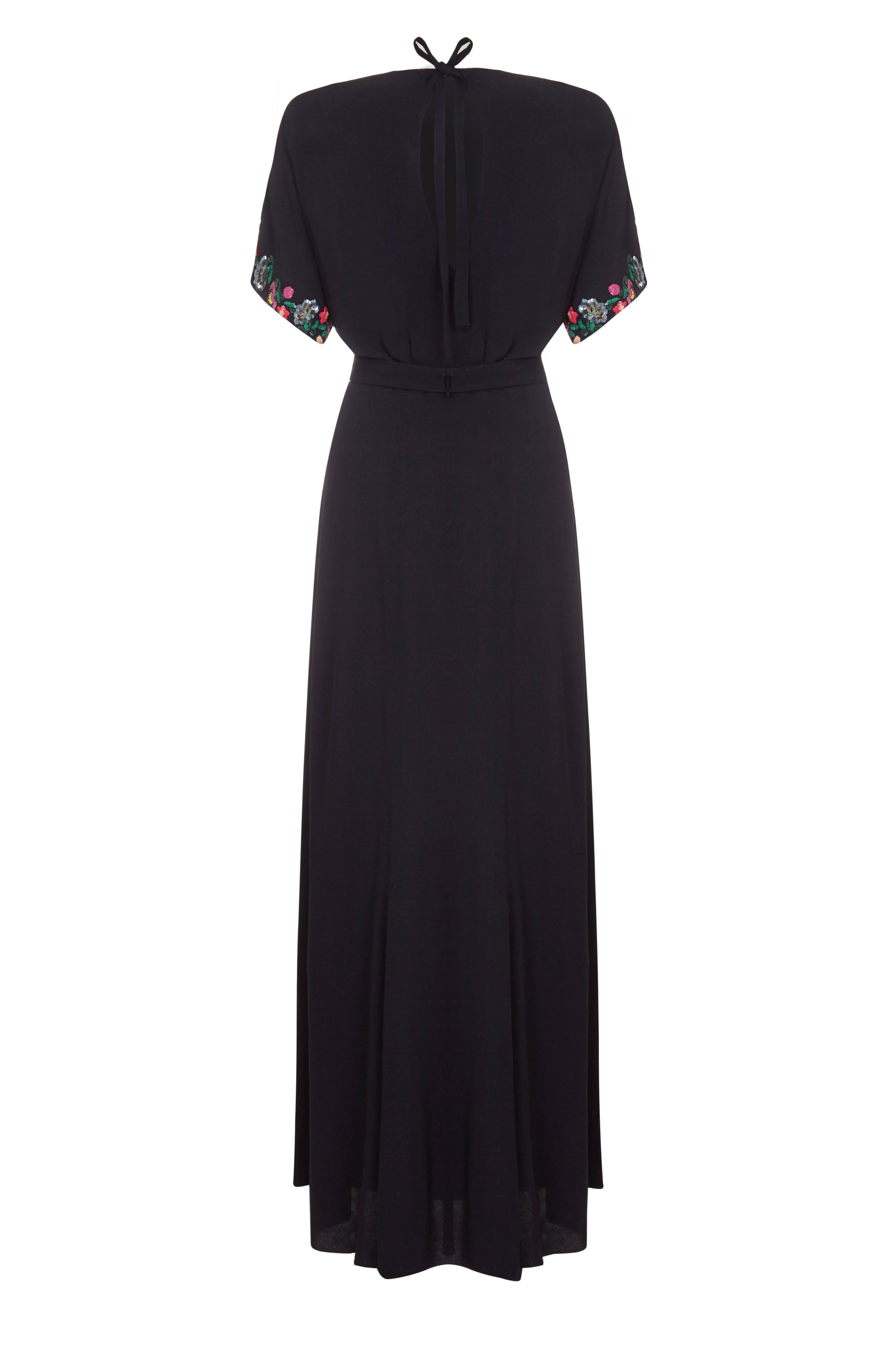 Amazing vintage 1940s full length black crepe dress with lovely multi-coloured floral sequin design on the sleeves and front of the attached belt.  This beautiful piece has flattering seams cut in to the skirt, and open back that ties at the neck