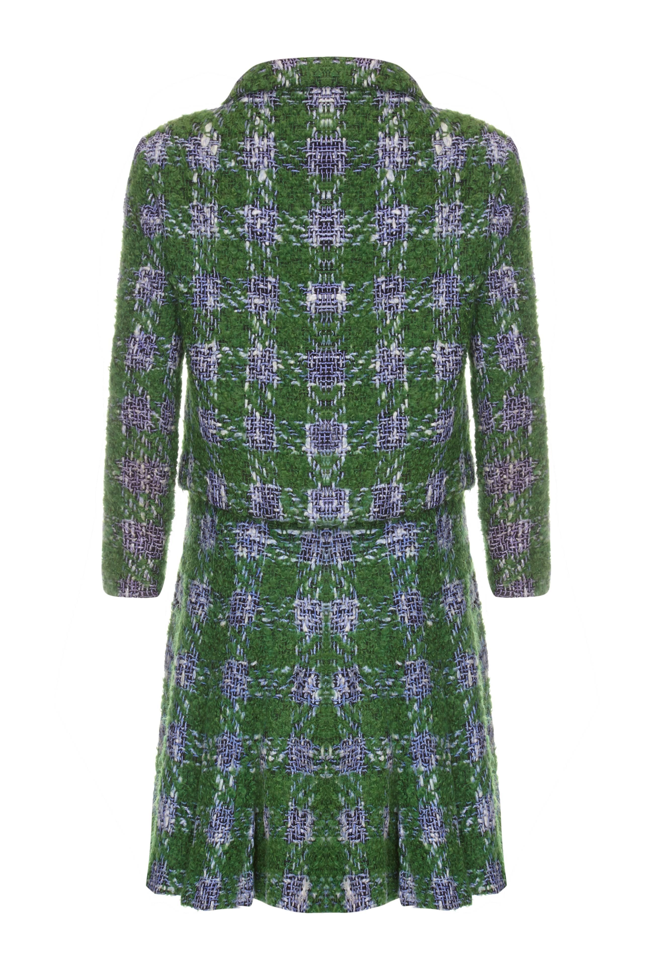 Beautiful vintage 1960s skirt suit from Bonwit Teller in a lovely textured green wool with blue and white yarns creating a check pattern.   The skirt is flared with pleats from the hip and fastens at the side with a zip.  The jacket is fully lined