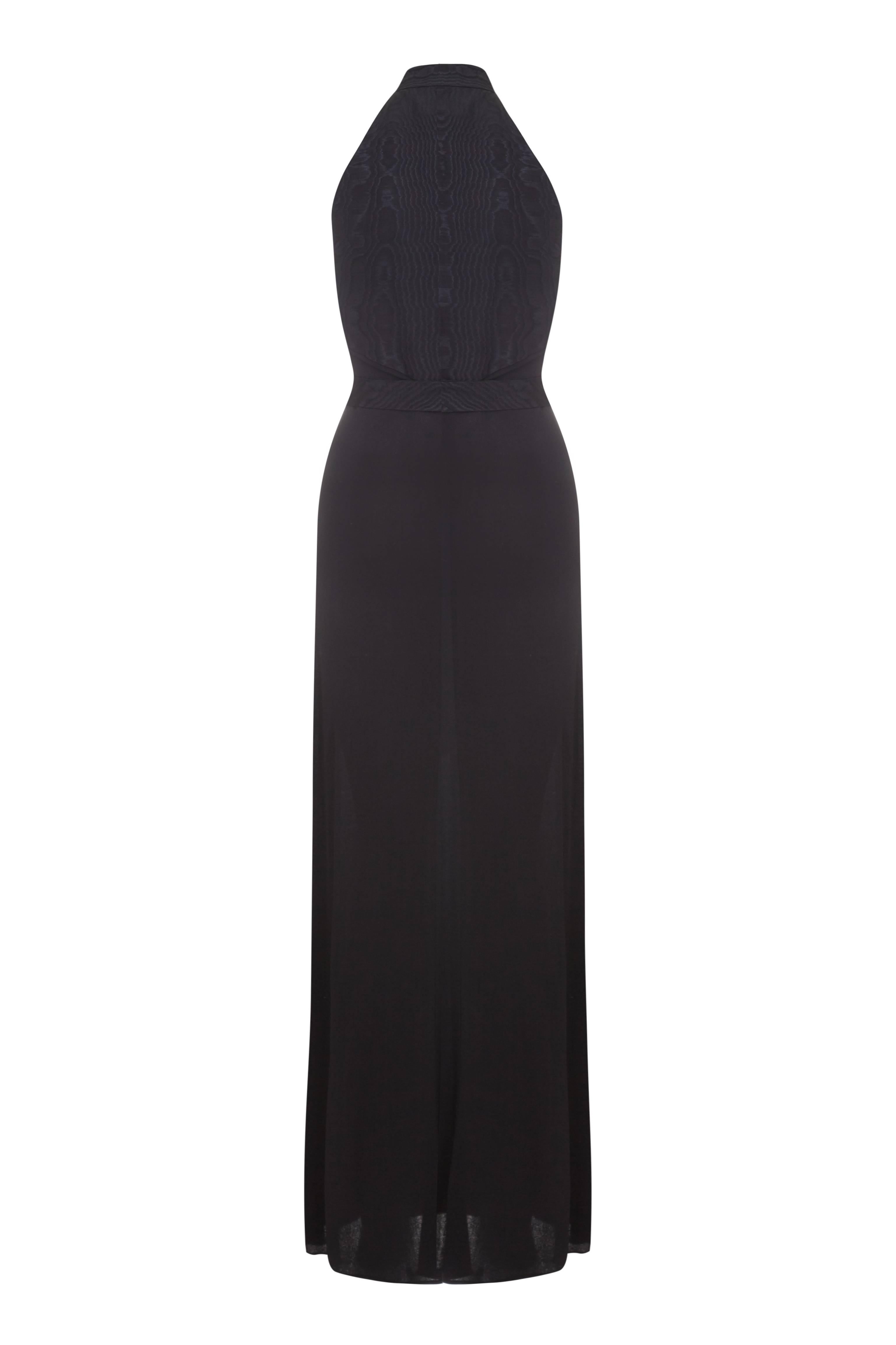 Beautiful vintage 1970s black jersey full length dress with halter neck and moire taffeta edging, belt and back bodice.  This piece is typical of the style of the day with an exaggerated collar, deep V neckline and button fastening down the front. 