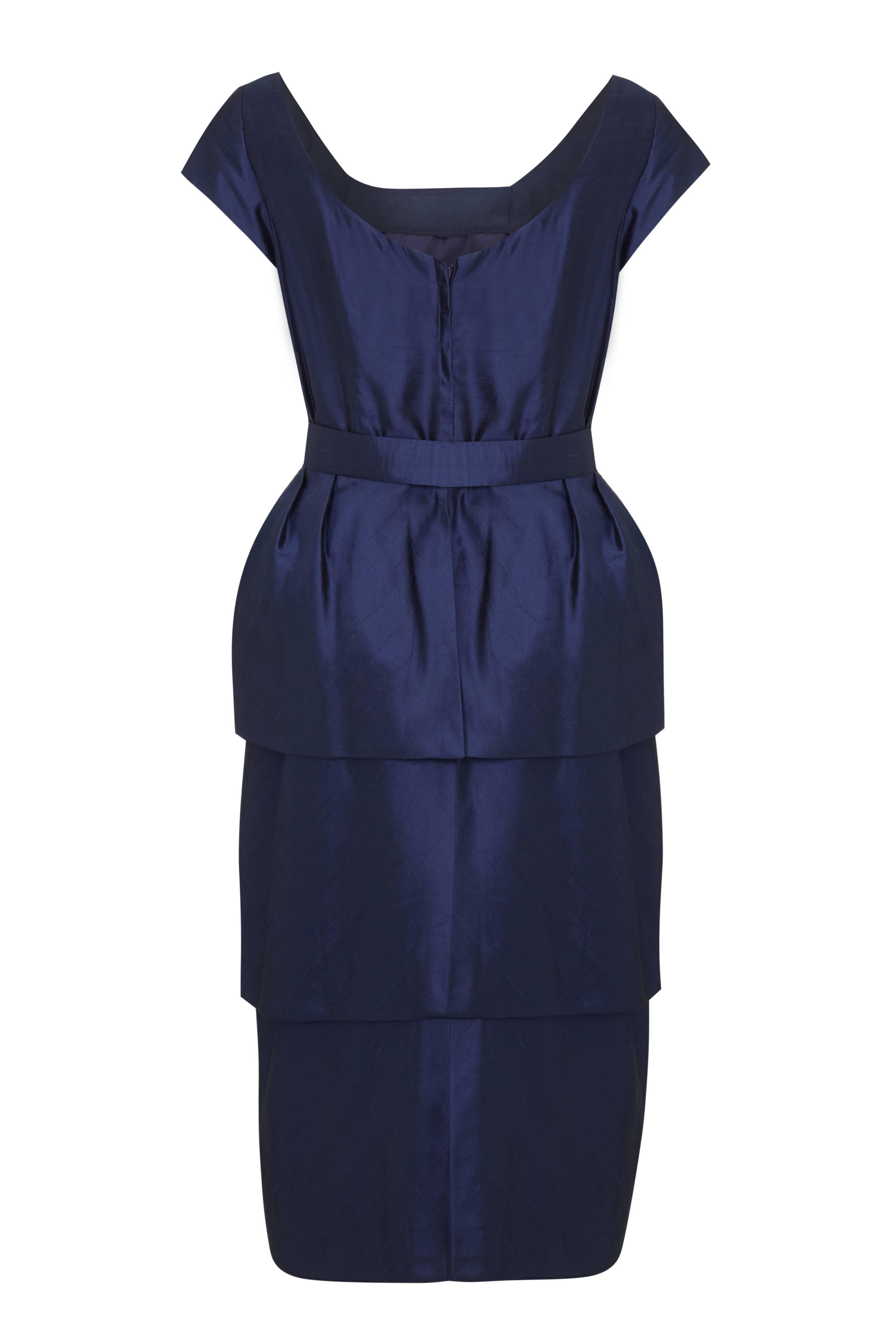Fantastic vintage 1950s navy silk dress with matching original bow belt.  The dress features a fun tiered petal skirt, cap sleeves and a low back.  Inside it is fully lined and in excellent condition with no flaws to mention. Would work best on