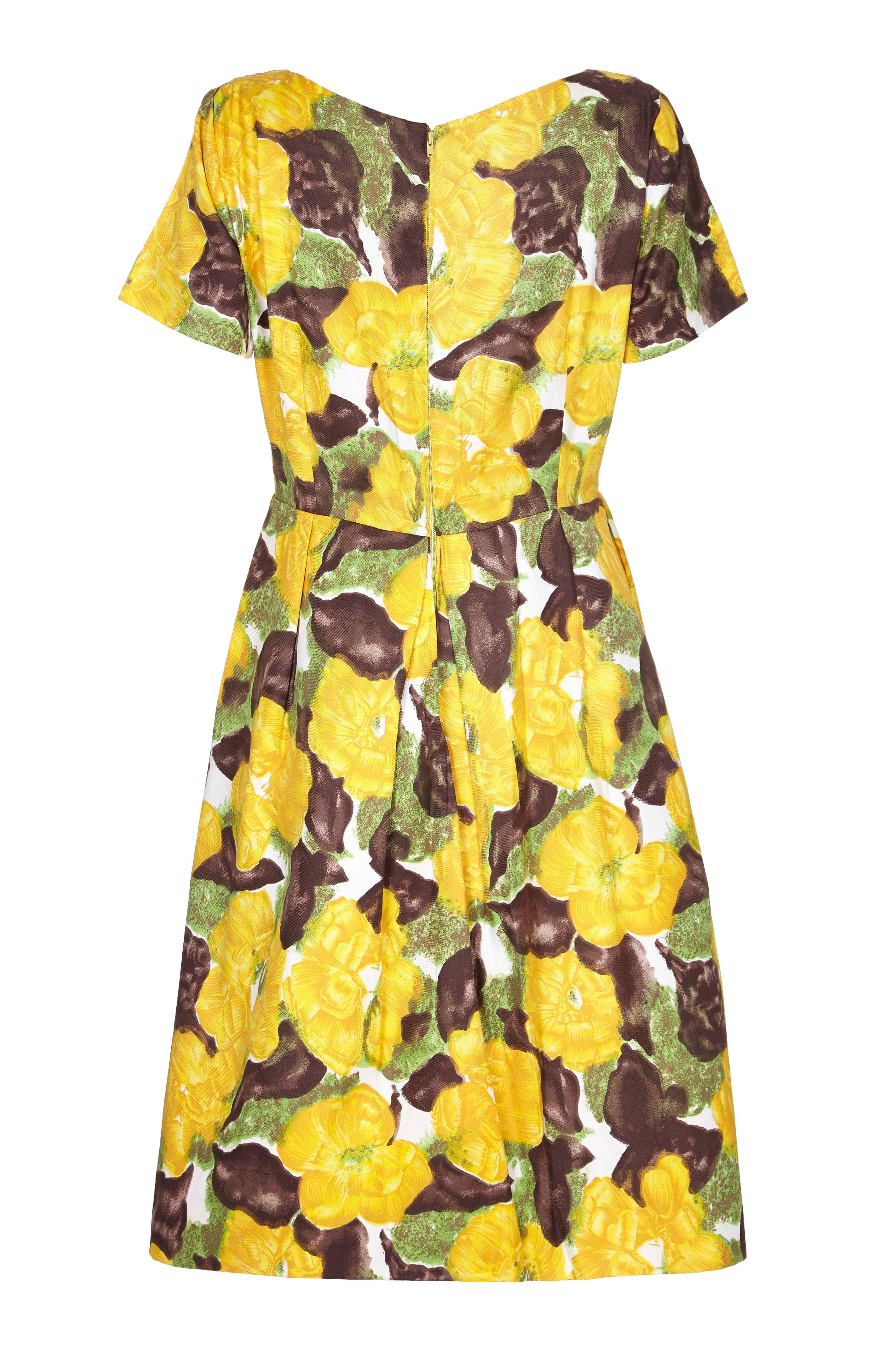 Lovely vintage 1950s cotton dress by British couture designer Patricia Anne with large yellow, green and brown floral print.  This dress features short sleeves, full skirt, pleated at the waist and a zip to fasten at the back. A great, beautifully