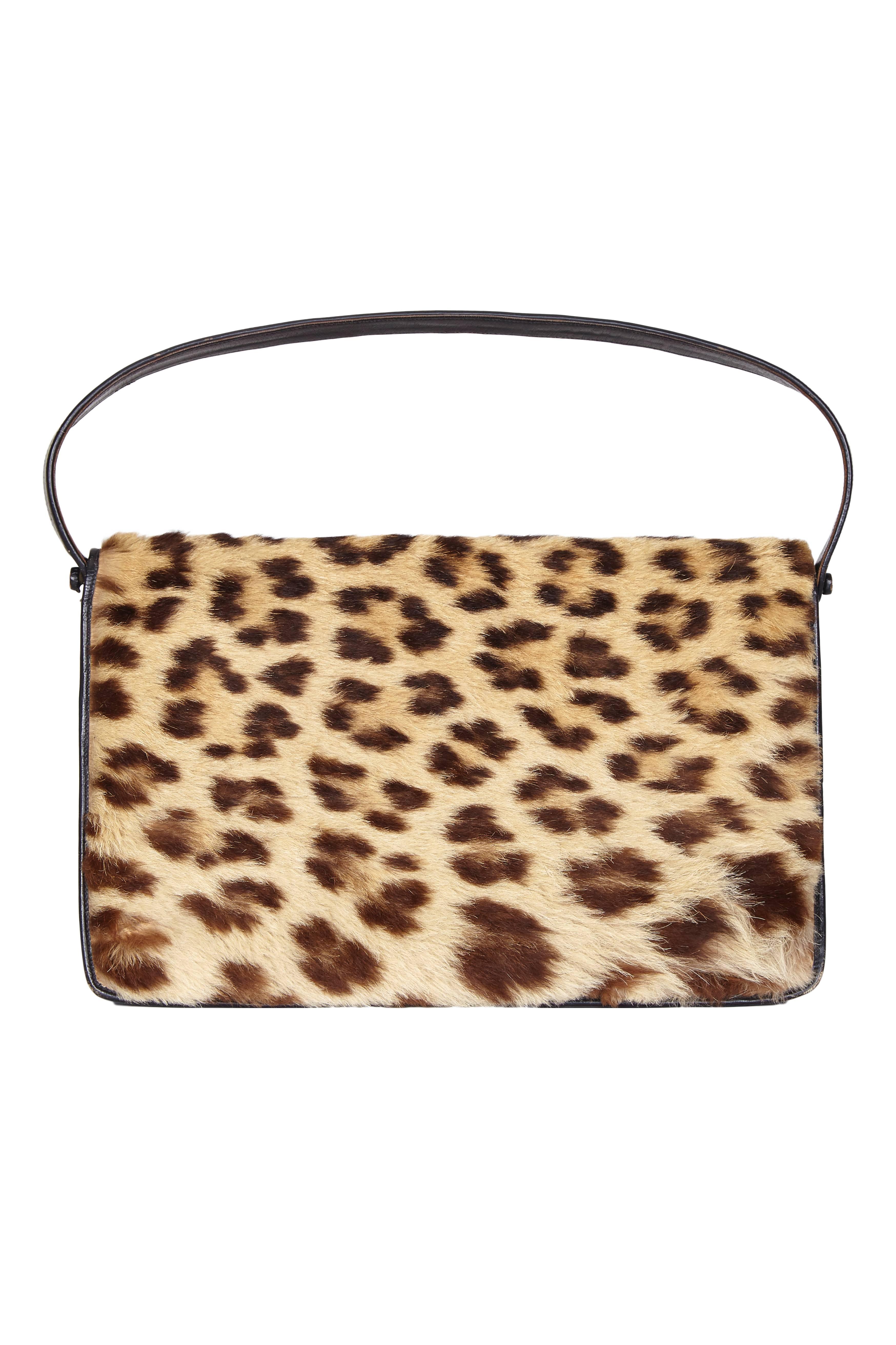 Incredible vintage 1950s leopard fur handbag with gilt clasp and black leather strap.  Inside the bag is split into two main sections with four smaller pockets, one with a zip closure. It is great fun and in very good condition with just a small