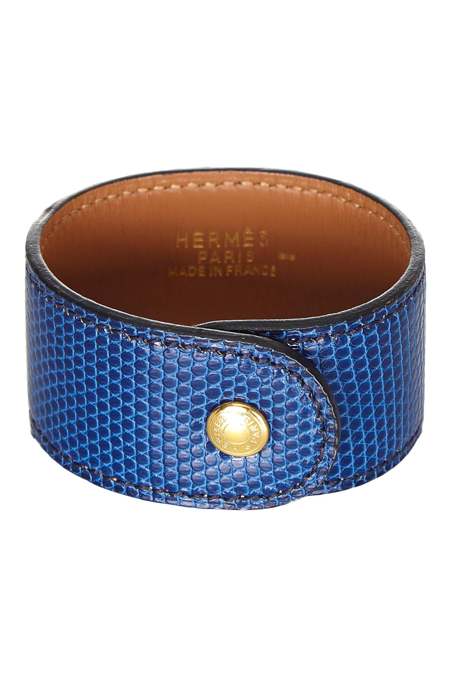 Hermes Medor bracelet in bright blue lizard leather with gold tone medor medallion stud and snap clasp fastening. Is in excellent used condition and comes with original box.

Total Length: 19cm/ 7.5"
When Fastened: 15.5cm/ 6"
Width: 3cm/