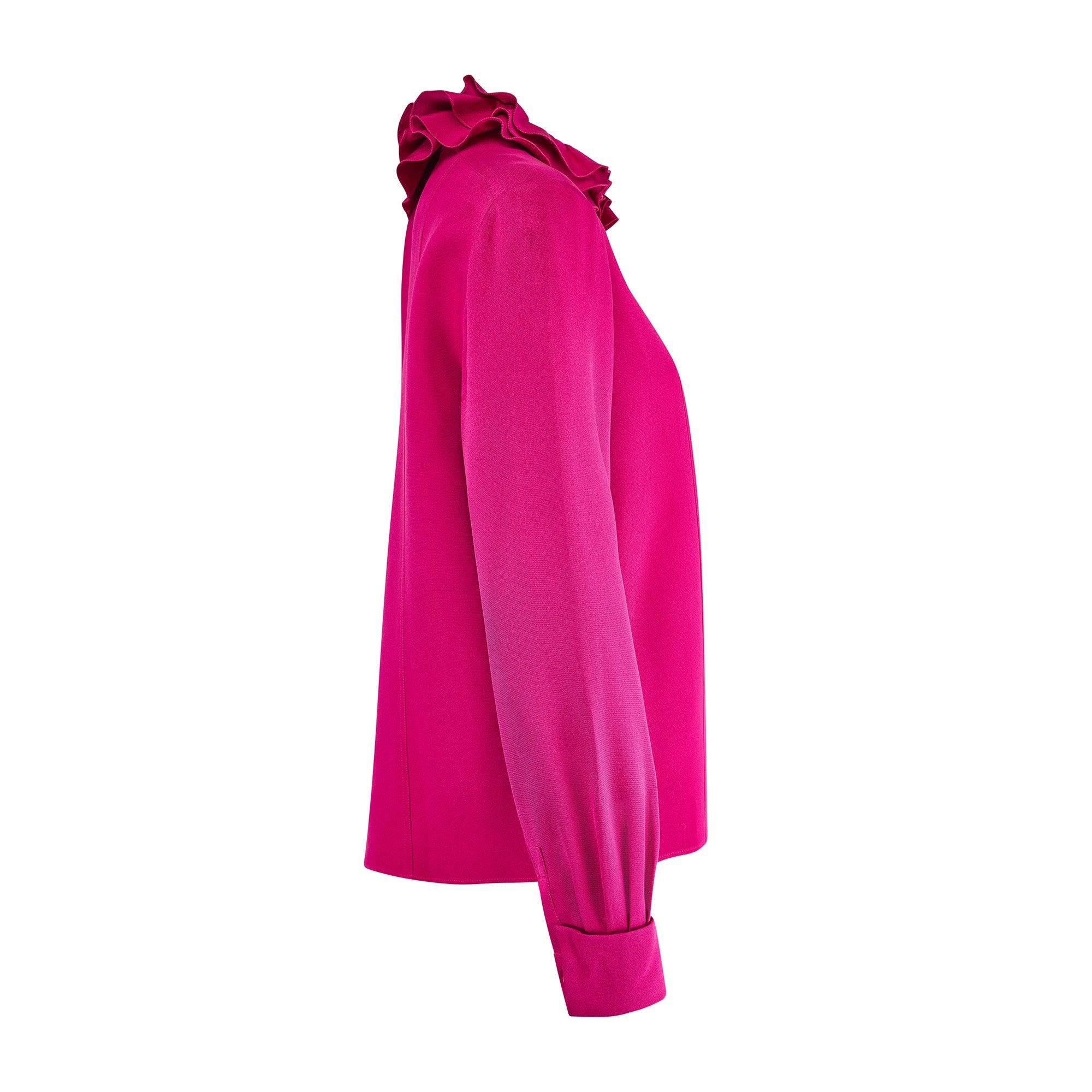 Fabricada en Italia, esta vibrante blusa Chanel de los años 80 con cuello de volante es uno de los primeros diseños de Karl Lagerfeld. Corte con un favorecedor ajuste ceñido al cuerpo en los paneles y mangas sueltas de corte más ancho. El tejido es