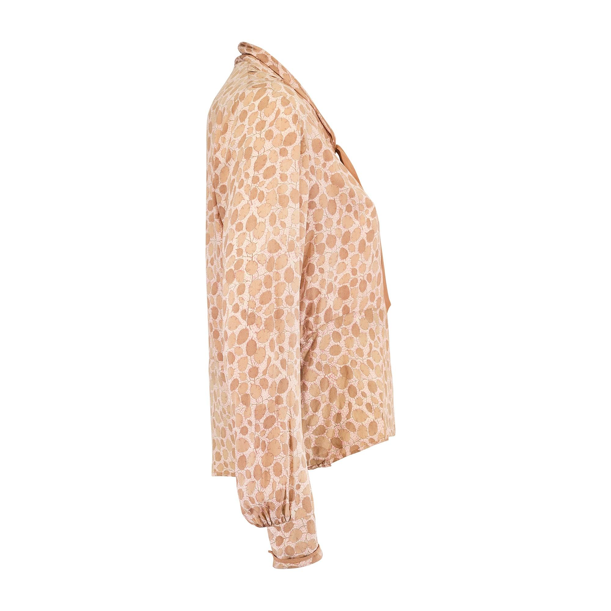 Superbe blouse en soie des années 1920 avec un joli imprimé de feuilles de lunaire dans des tons caramel doux sur un fond crème abstrait. Il est taillé dans une coupe ample et comporte des panneaux. Le col châle est bordé de soie caramel et se ferme