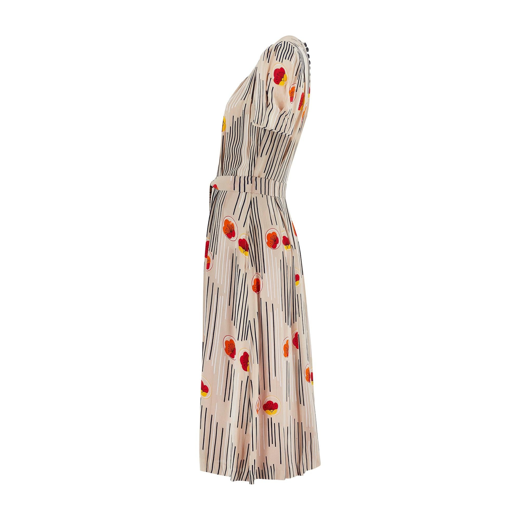 Cette robe midi imprimée d'inspiration Art déco a été conçue dans les années 1970 par le célèbre designer britannique Jeff Banks, bien qu'elle ne porte pas d'étiquette. Cette robe a été achetée en même temps qu'un grand nombre d'articles