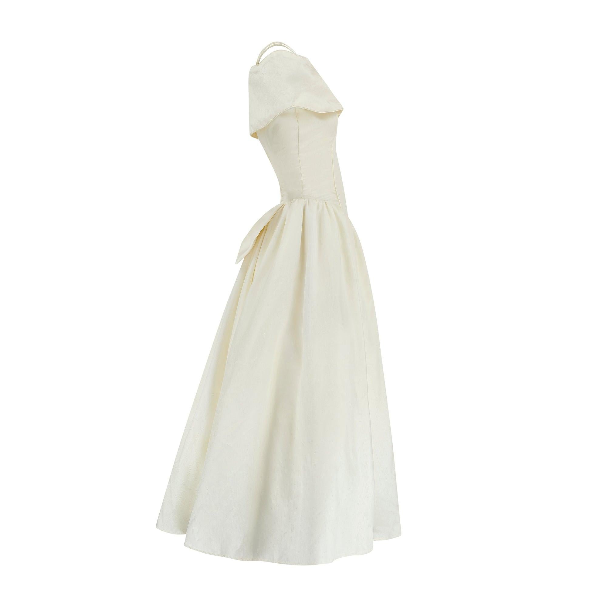 Vers la fin des années 1990, cette robe de mariée a été taillée dans un mélange de soie ivoire et fabriquée en Angleterre par la marque britannique Margaret Lee. La silhouette romantique a un air amusant des années 1980, mais nous sommes presque