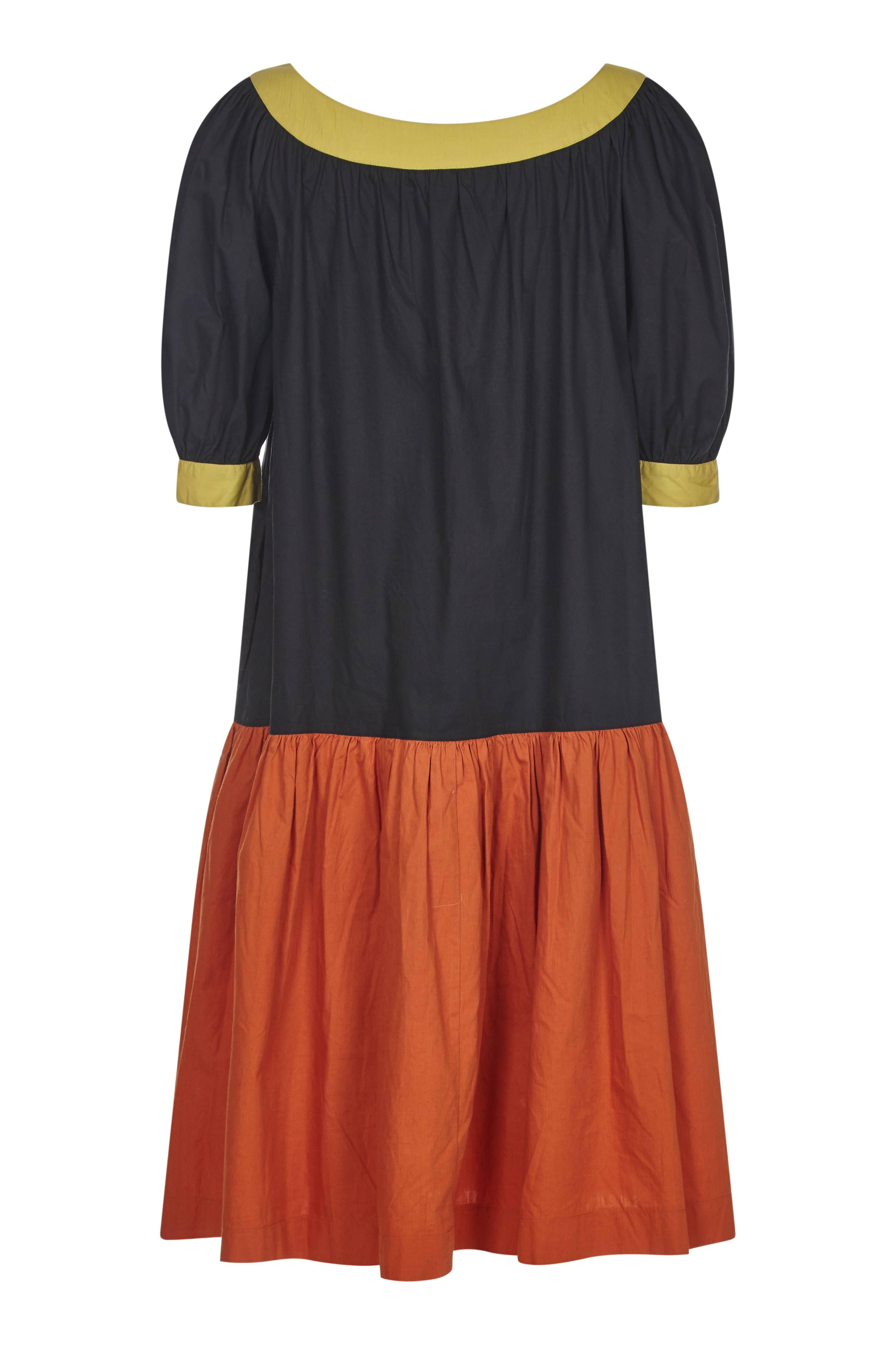 Charming Yves Saint Laurent Variation 1980s cotton peasant dress with dropped waist and billowed sleeves. The dress is 100% crisp cotton fabric in block colours ochre, warm rust and black, with a gentle scoop neck and voluminous selves that are