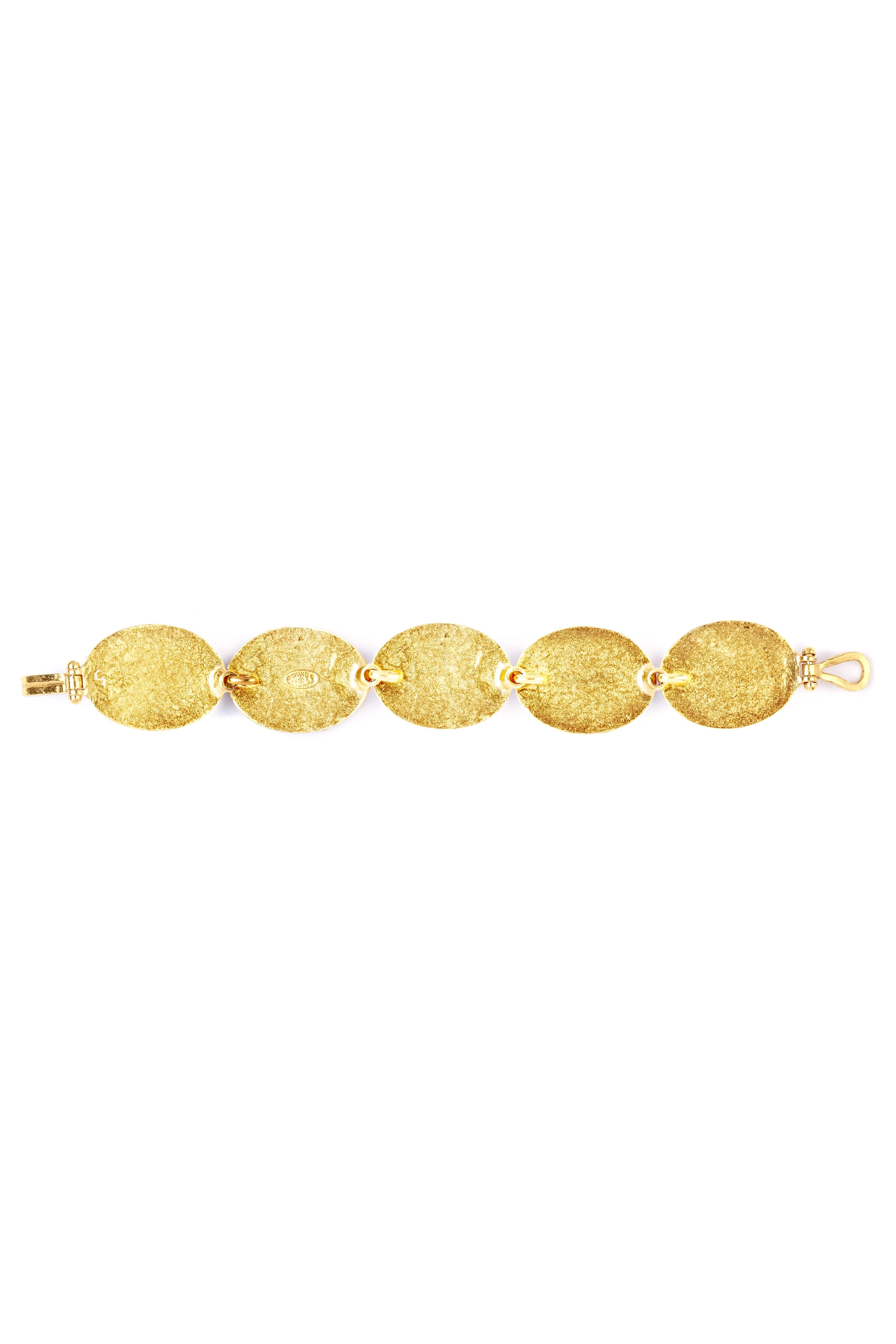 This stunning Chanel bracelet is in excellent condition and timelessly elegant in its simplicity. Five large oval links (1.2in length,1in width) made of polished faux jade and set into gold leaf are then fastened by an oversized hook and eye. The