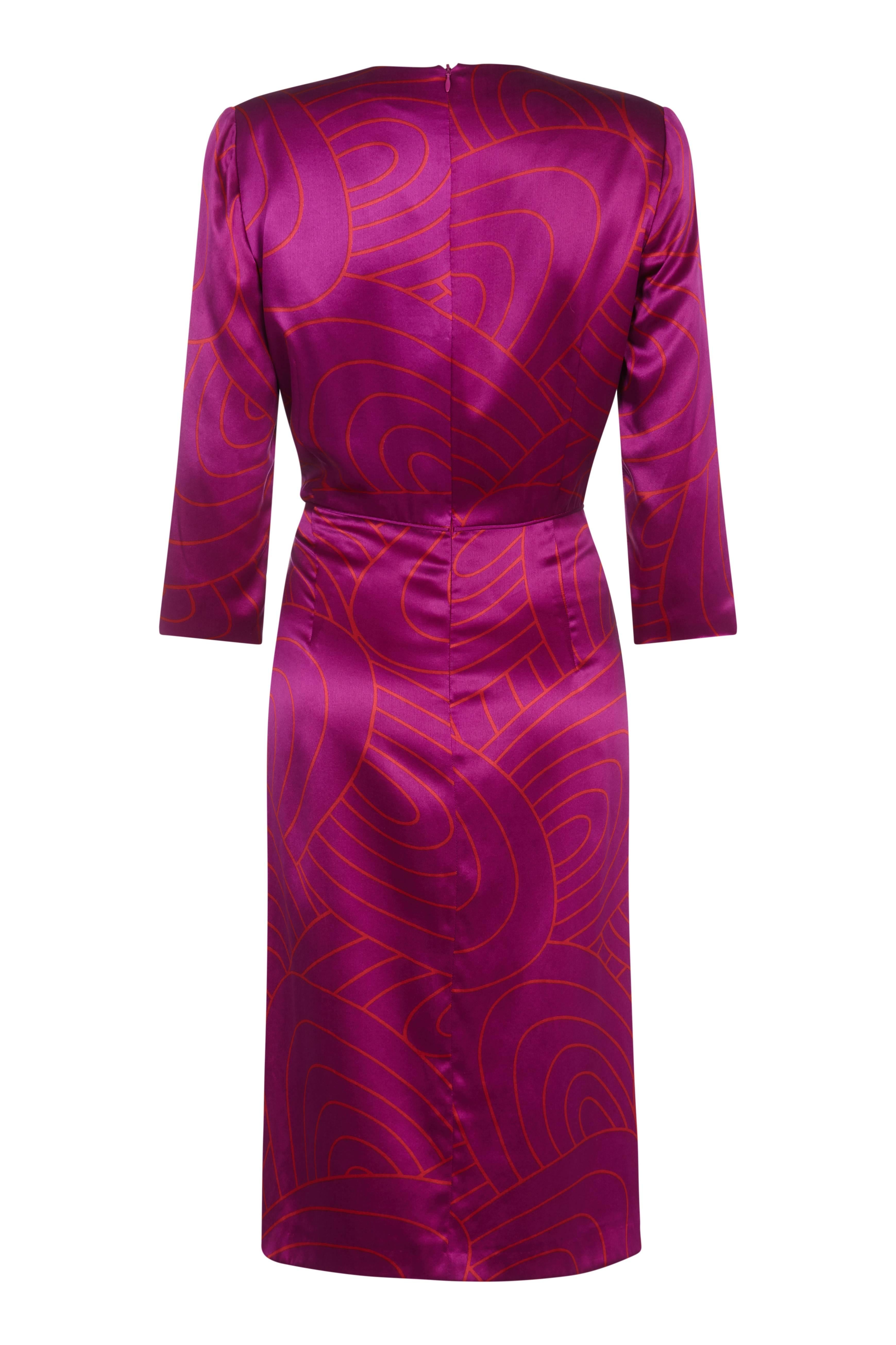 This seductive 1990s Louis Feraud hot pink silk dress with wrap around detail is  sure to turn heads at the next party. The alluring shade of pink is enhanced by the 60s style swirling design in warm orange which has a wonderful interplay over the