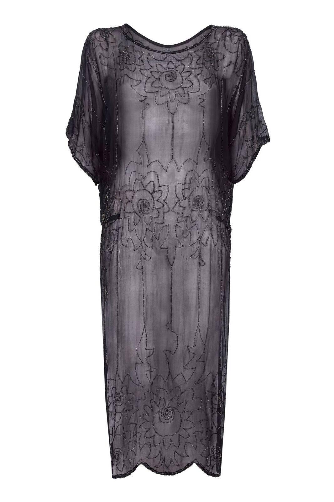 This exquisite 1920s silk chiffon flapper dress is in immaculate condition, especially for a piece of this period. The delicate rocaille bead embellishments are black and bronze flecked and give weight to the featherlight fabric. The Art Deco floral