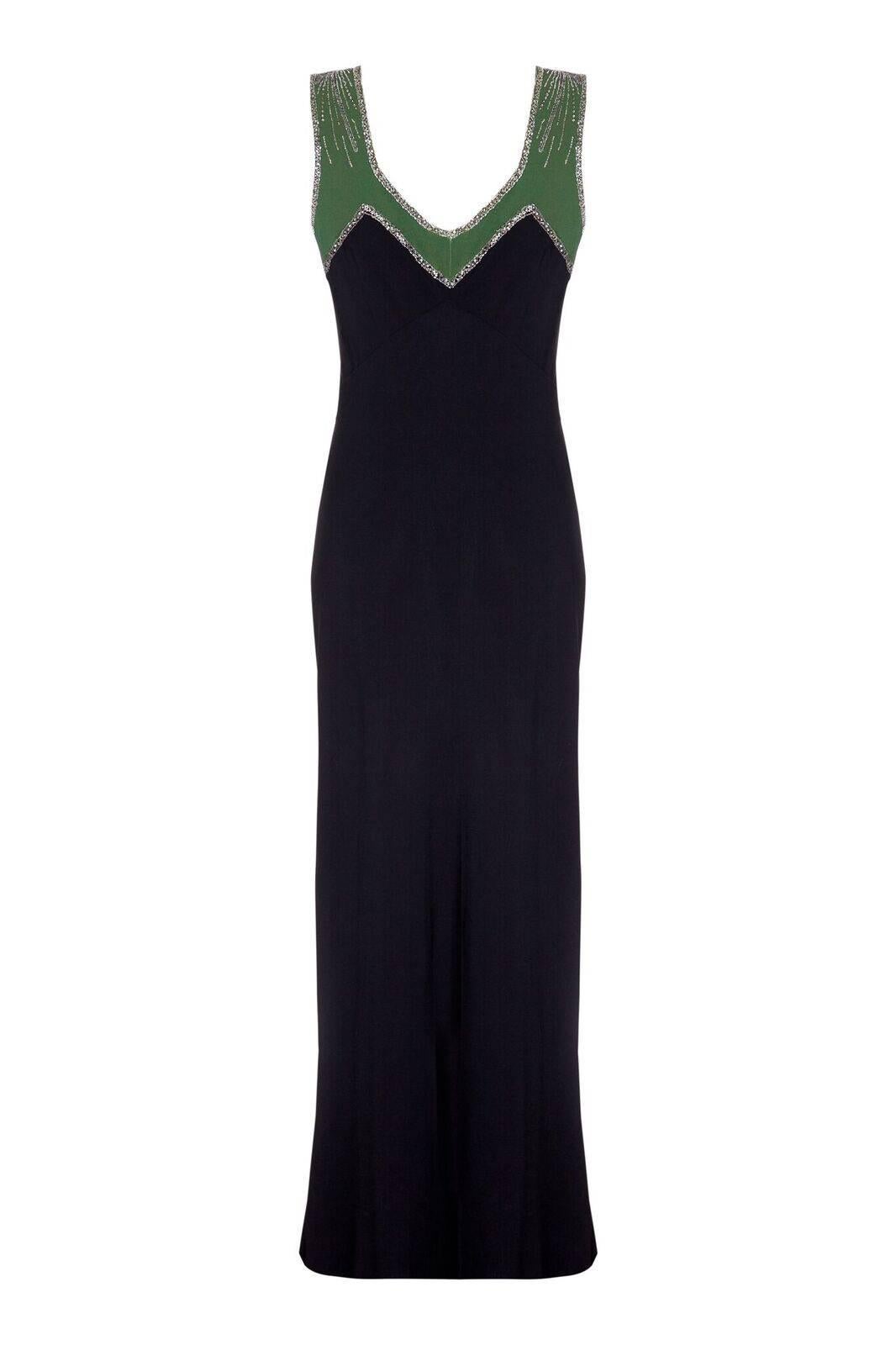 This sensational 1930s Art Deco evening gown boasts the winning combination of elegant line and exquisite embellishment. The silk crepe fabric is predominantly black, with a panel of forest green artfully placed around the centre front and neckline