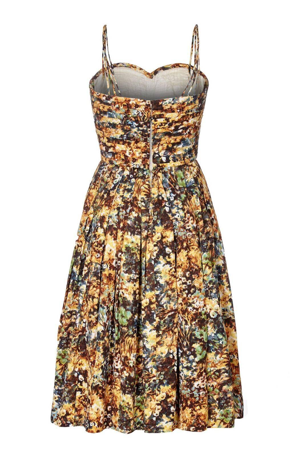 This charming 1950s printed couture dress is beautifully constructed with some exquisite features. The overlay fabric is a silky/cotton blend and printed with an unusual floral design in ochre, rust, chocolate brown and green. The sweetheart