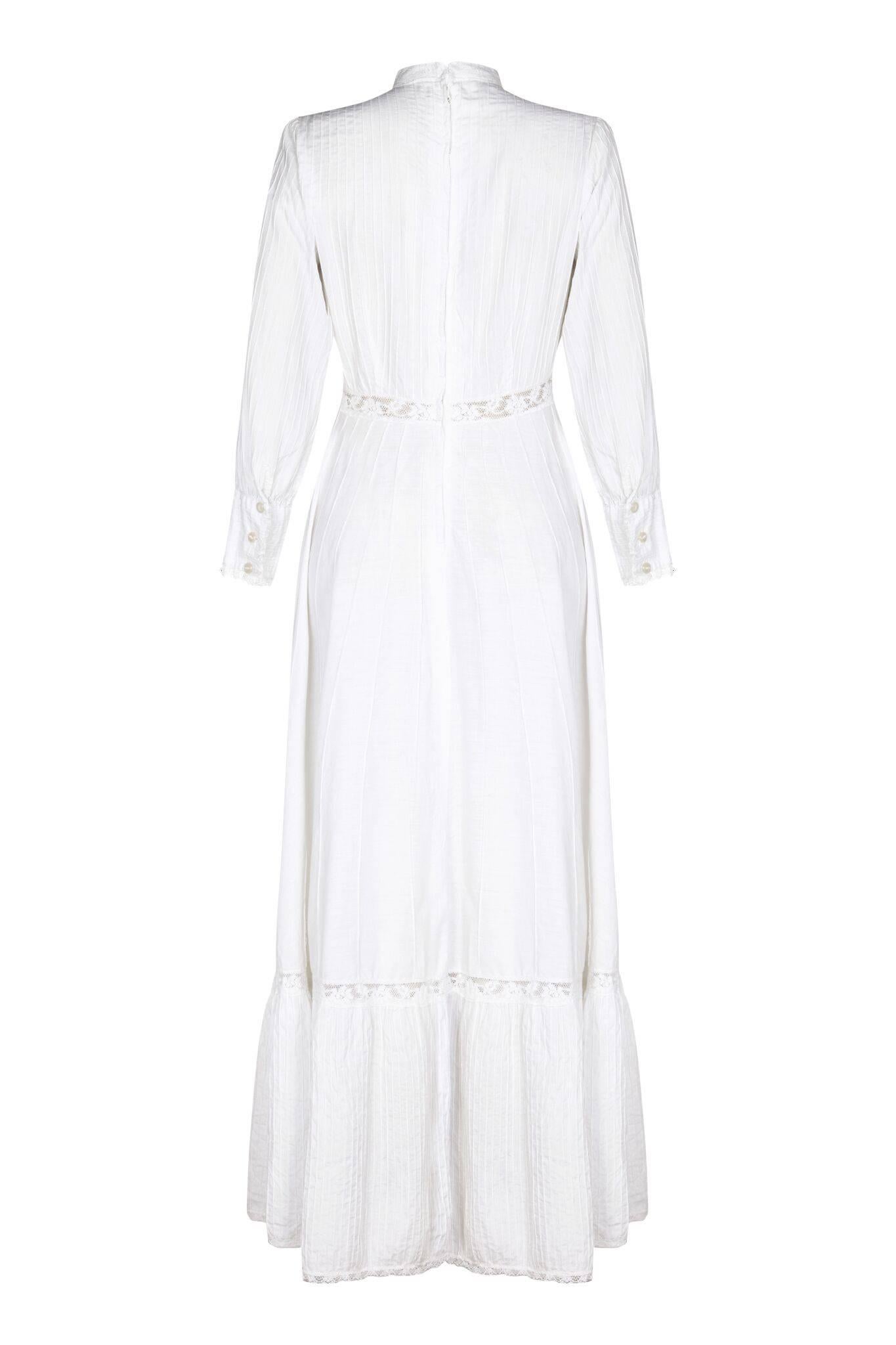 This beautiful 1970s white cotton lawn/prarie dress is in superb condition and is a classic example of the Edwardian/Victorian style that was famously popularised by Laura Ashley during this era. The soft cotton delicate pin-tuck detail is