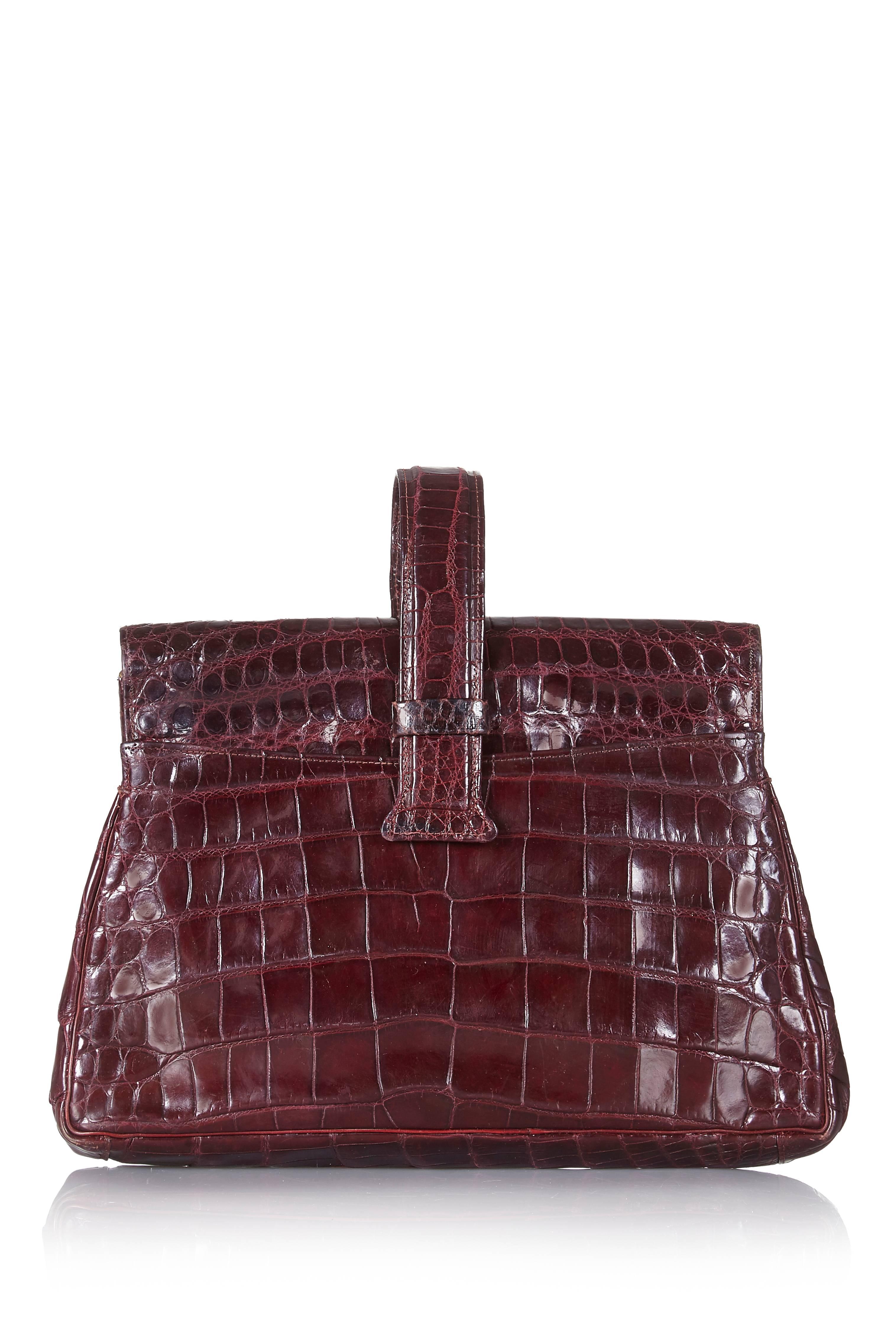 This charming 1940s and large for the era, crocodile skin clutch bag in deep burgundy is in superb vintage condition.  The skin is soft and supple having developed a shiny patina over the years. Beautifully made and in a traditional trapezium shape