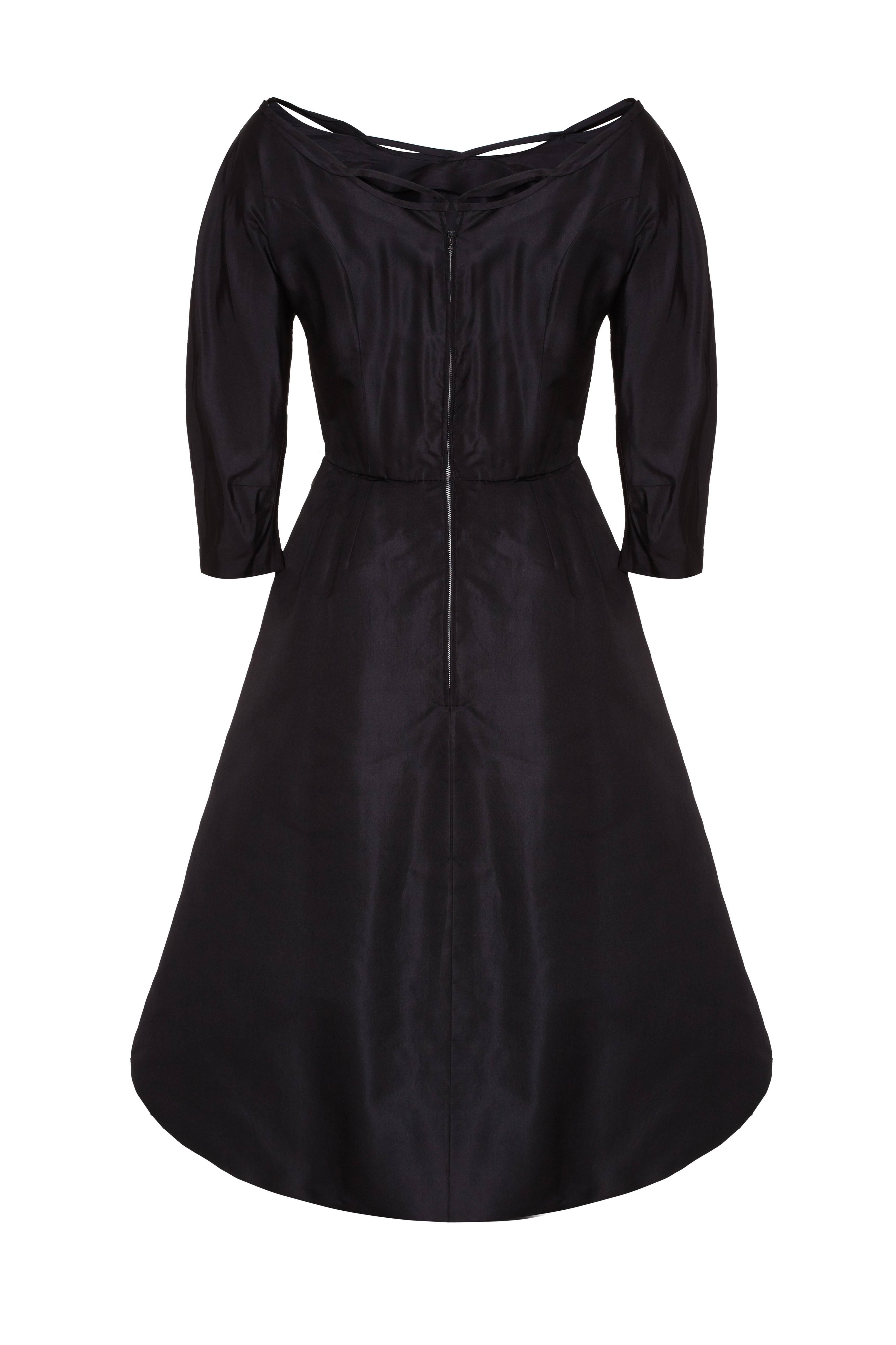 This late 1940s or early 1950s black taffeta silk dress is by internationally acclaimed American designer Ceil Chapman and of complex construction.  The dress has a beautiful fitted bodice with a boned internal waspie to shape the waist.  The