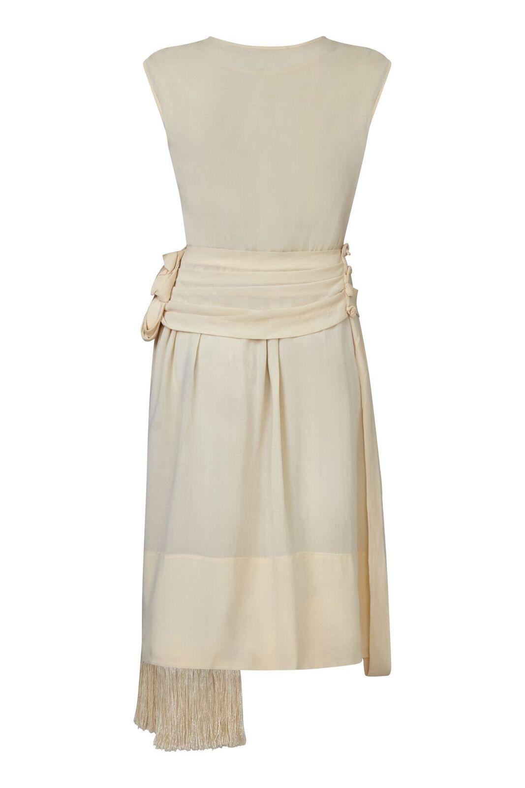 This exquisite 1920s Flapper style dress is in excellent vintage condition and of remarkable construction. The soft cream silk crepe fabric has been expertly tailored to create an elegant drop waist with a shift style overlay which gathers to the