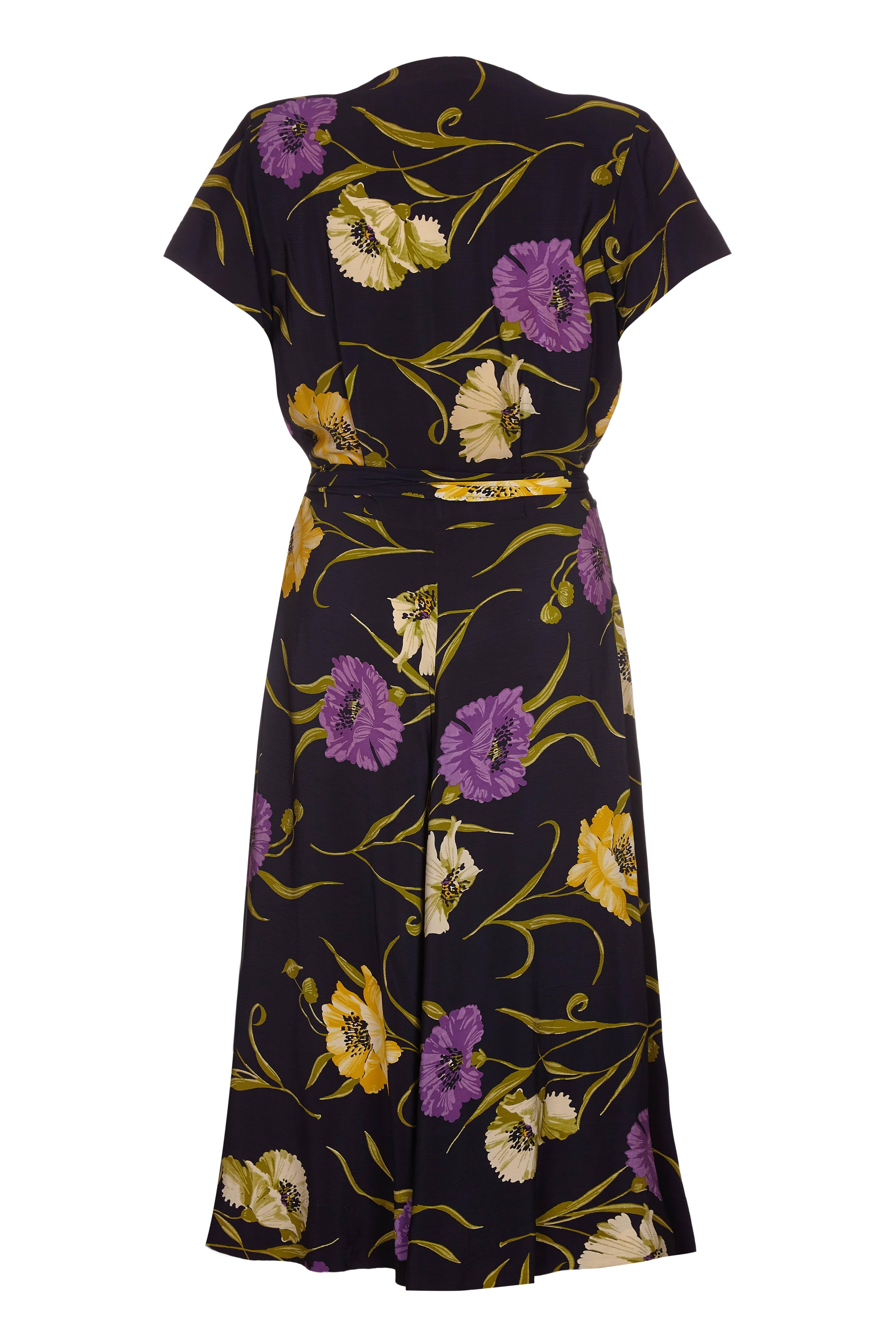A Klafter and Sobel navy rayon floral crepe dress from the 1940s with matching waist tie. This dress is versatile as it can be dressed up or down for both evening and day. The pretty sweetheart neckline has pleated detailing on both sides and