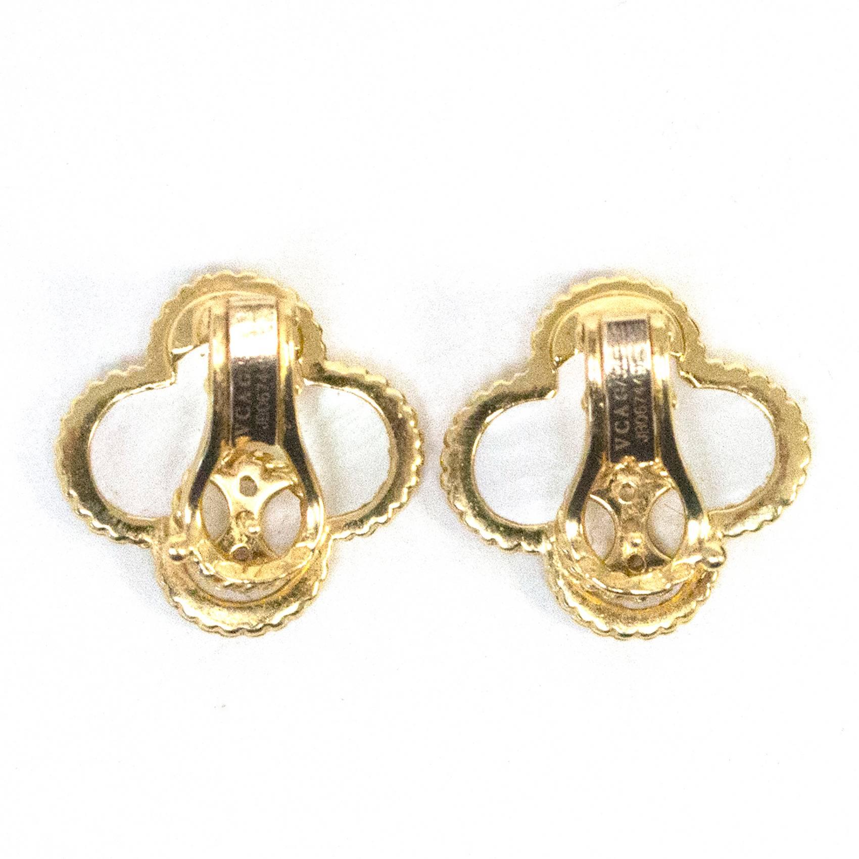 Van Cleef & Arpels 'Magic Alhambra' ear-clips in 18 carat yellow gold and white mother-of-pearl. Beautiful mother of pearl in iconic flower shape surrounded by yellow gold. Stud post and hinged backing to earrings.
These earrings are sold out and