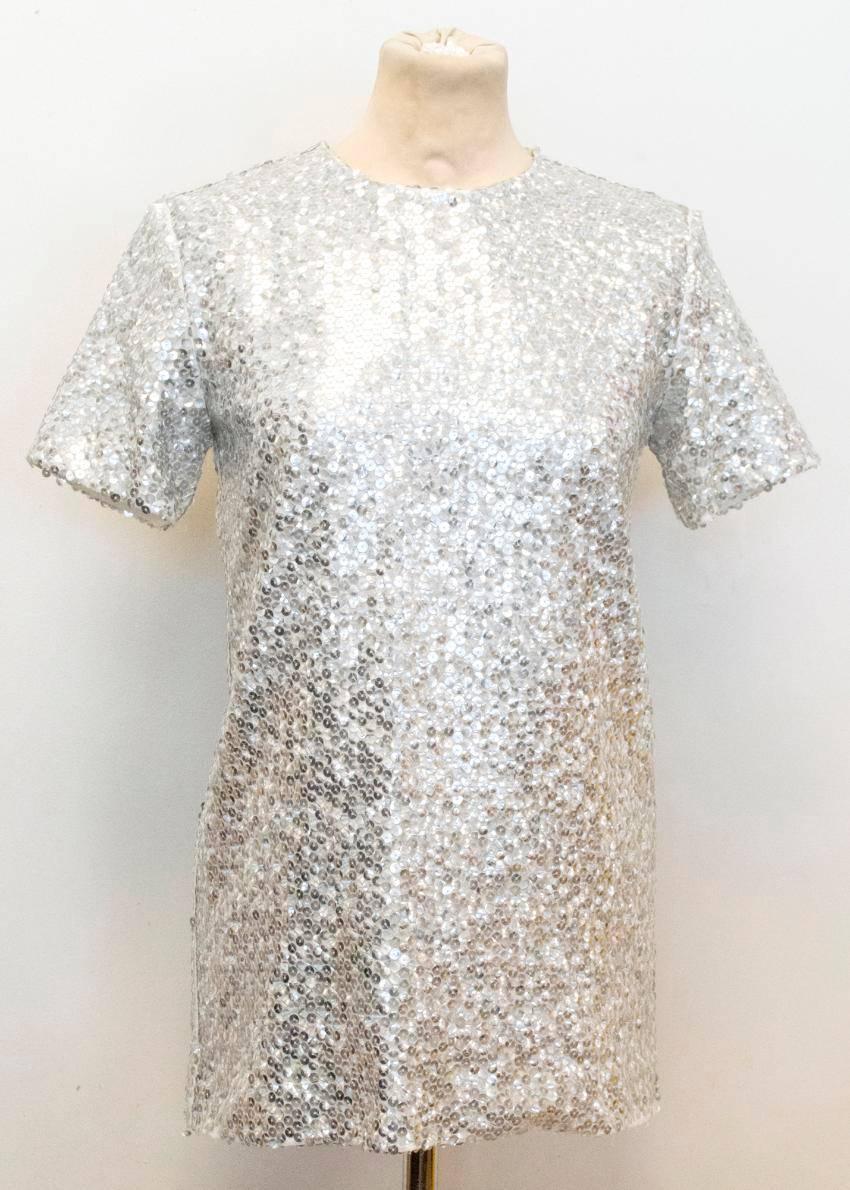 Nina Ricci silver sequined voile t-shirt top. This t-shirt is long in length and features a silk-polyester blend lining as well as an invisible zip at the back of the top.

There are some missing sequins on the item's sleeve and bottom hem, (please