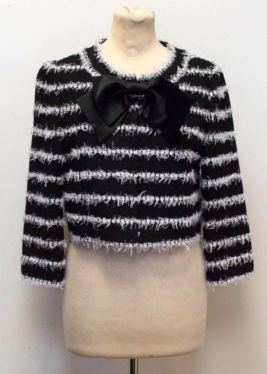 St. John black knitted collarless cropped jacket with white textured horizontal stripes and a large black silk bow on the neckline. Size US 6.

The jacket is fully lined, soft to the touch, has a box fit and hook closure 

Made in the USA.