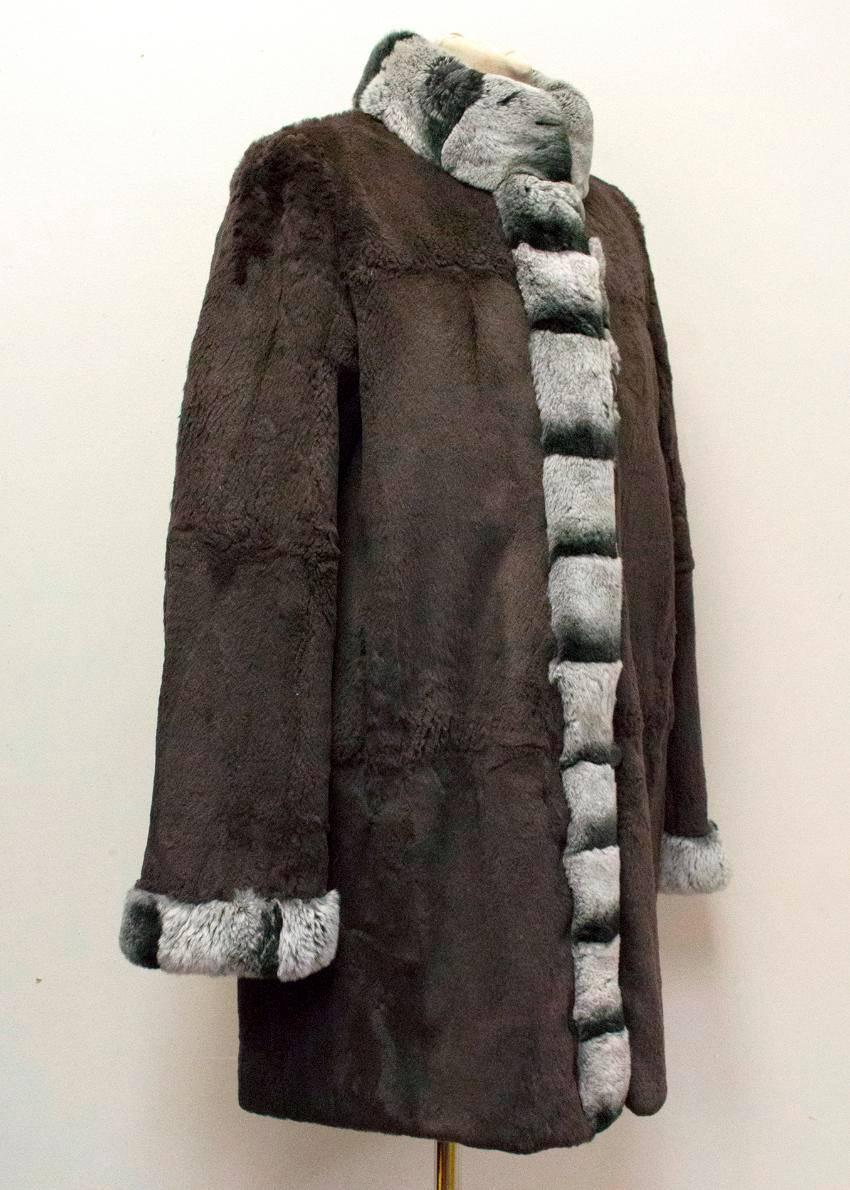 Grey chinchilla fur and silk reversible coat with a brown fur side featuring a grey fur trim and a grey silk side featuring grey fur trim.

The coat has a high beck, chinchilla trim on the neck, cuffs and along the front with front button closure.