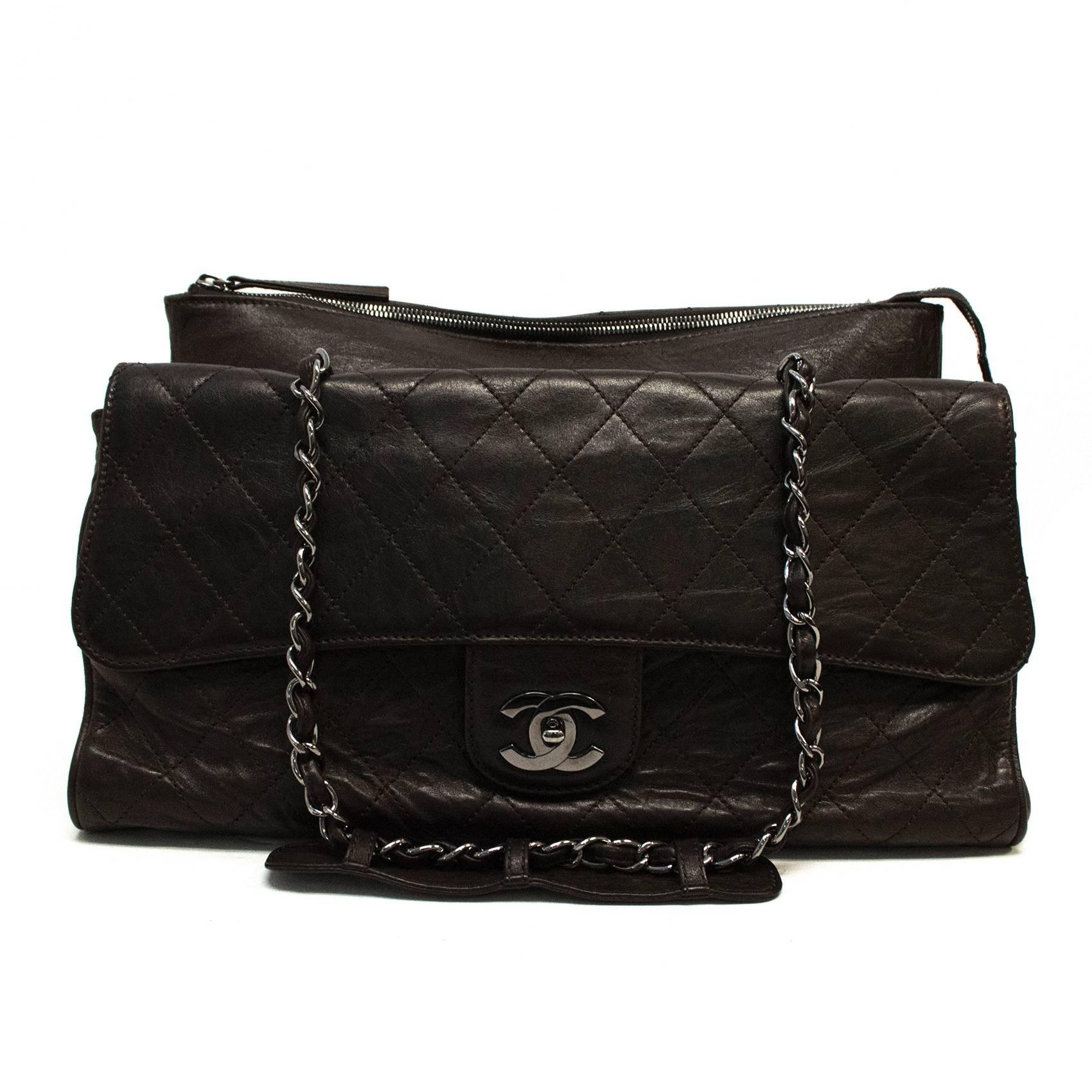 This versatile Chanel bag features an exterior envelope closure compartment and a back zip closure compartment. The middle compartment is in a gladstone shaped bag and it closes with a Chanel motif latch. The interlaced silver chain shoulder straps