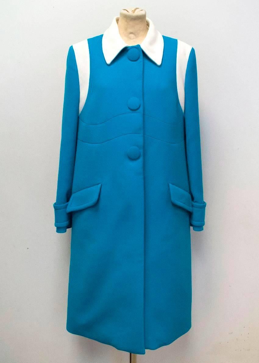 Prada bright blue top coat with a white collar, white shoulder panels and three button closure. The coat has a relaxed fit with two flap pockets and buckled cuffs.

Made in Italy. Size 10.

Please note that there is a very small hole and mark on