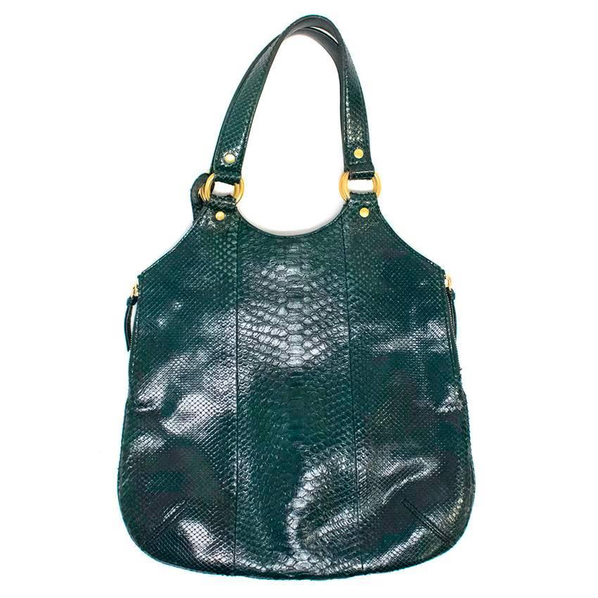 Yves Saint Laurent  dark green, snake skin 'Tribute' tote. It features gold hardware, a top magnetic closure and a double top handle. The interior is fully lined and features one main compartment with two zipped side pockets and a detachable