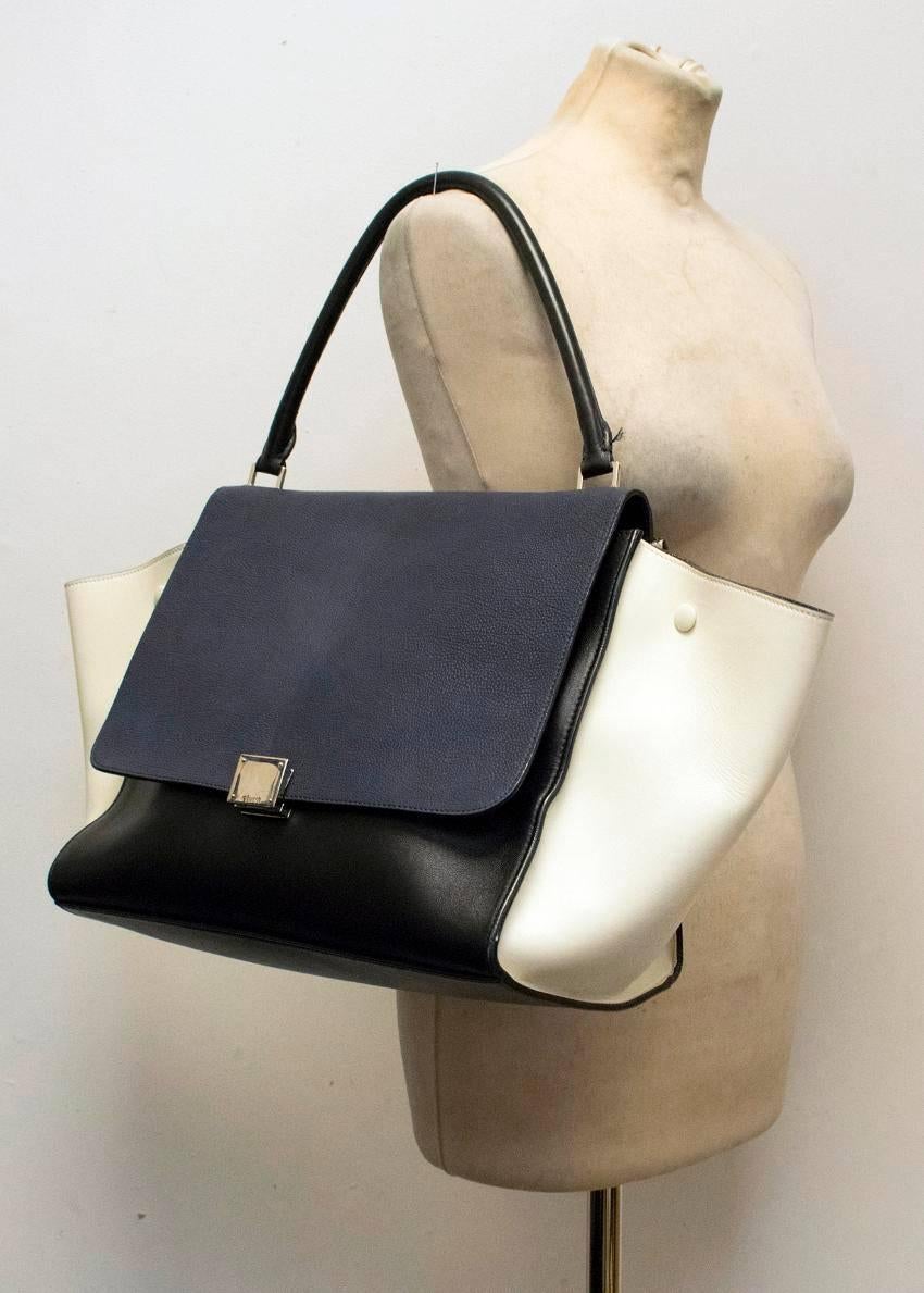 Celine Trapeze bag in black, white and navy featuring black suede lining and silver hardware, single top handle, flap front and zipped pocket to the back.

Original dust bag included. Made in Italy.

Great condition with slight signs of wear to