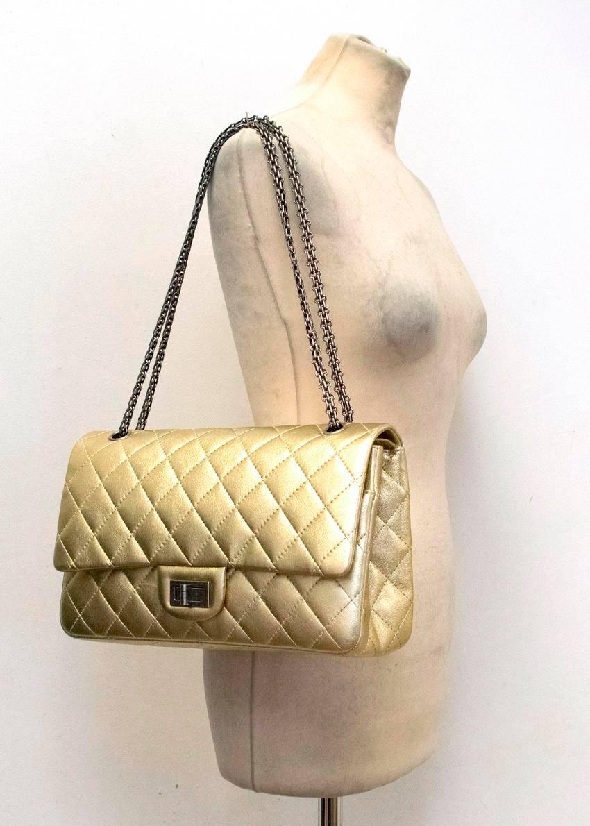 Chanel gold leather flap bag with metal chain straps and a twist fastening, one exterior pocket and decorative stitching in a check design. The interior features one main compartment with separate side pockets. 

Conditions Details : There are some