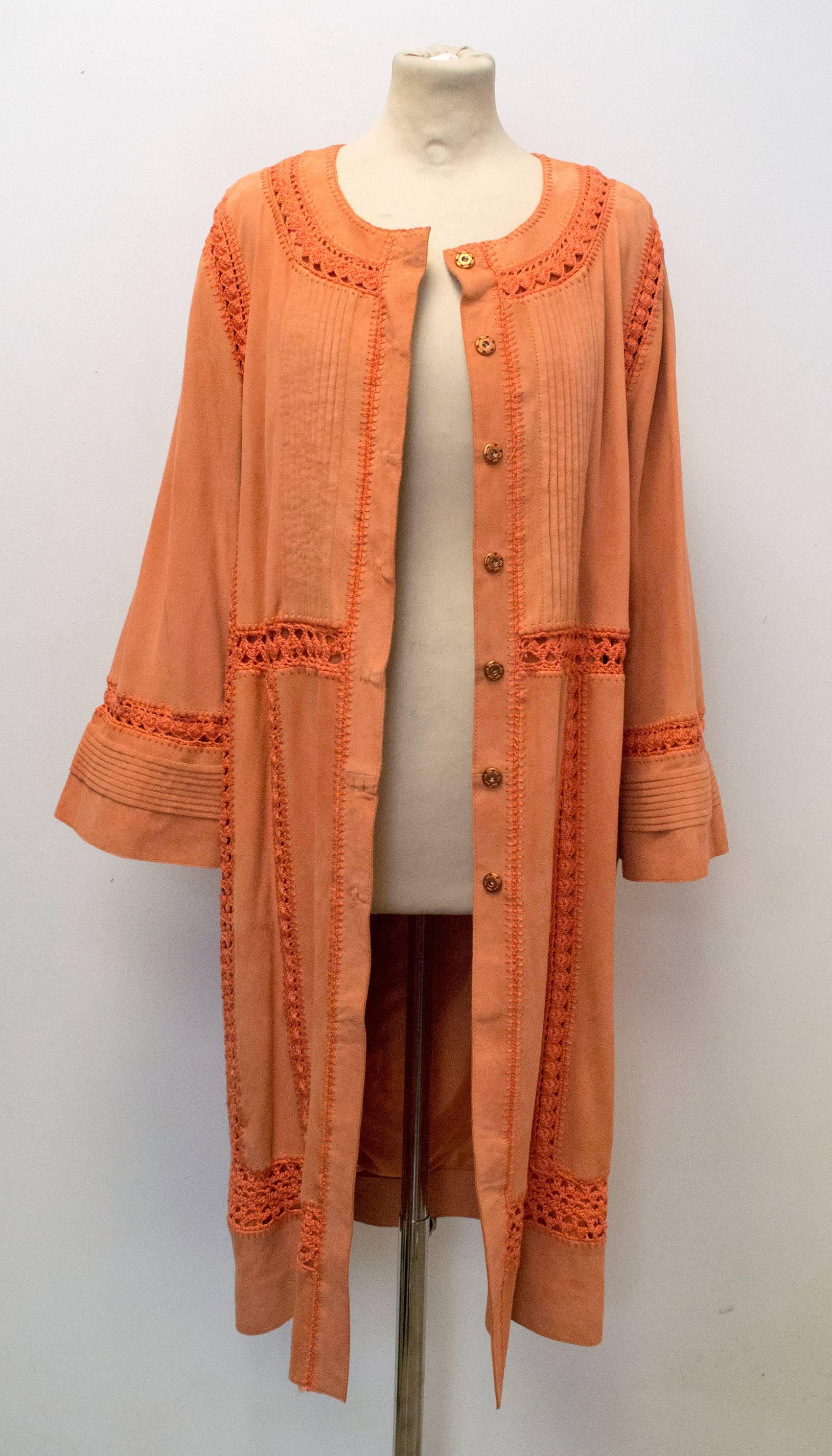 Bright orange suede goatsking coat.  The coat is done up using the seven invsible poppers down the front.  There is  woven in crochet detailing running vertically down each side of the front and back of the jacket, as well as around the neckline, on