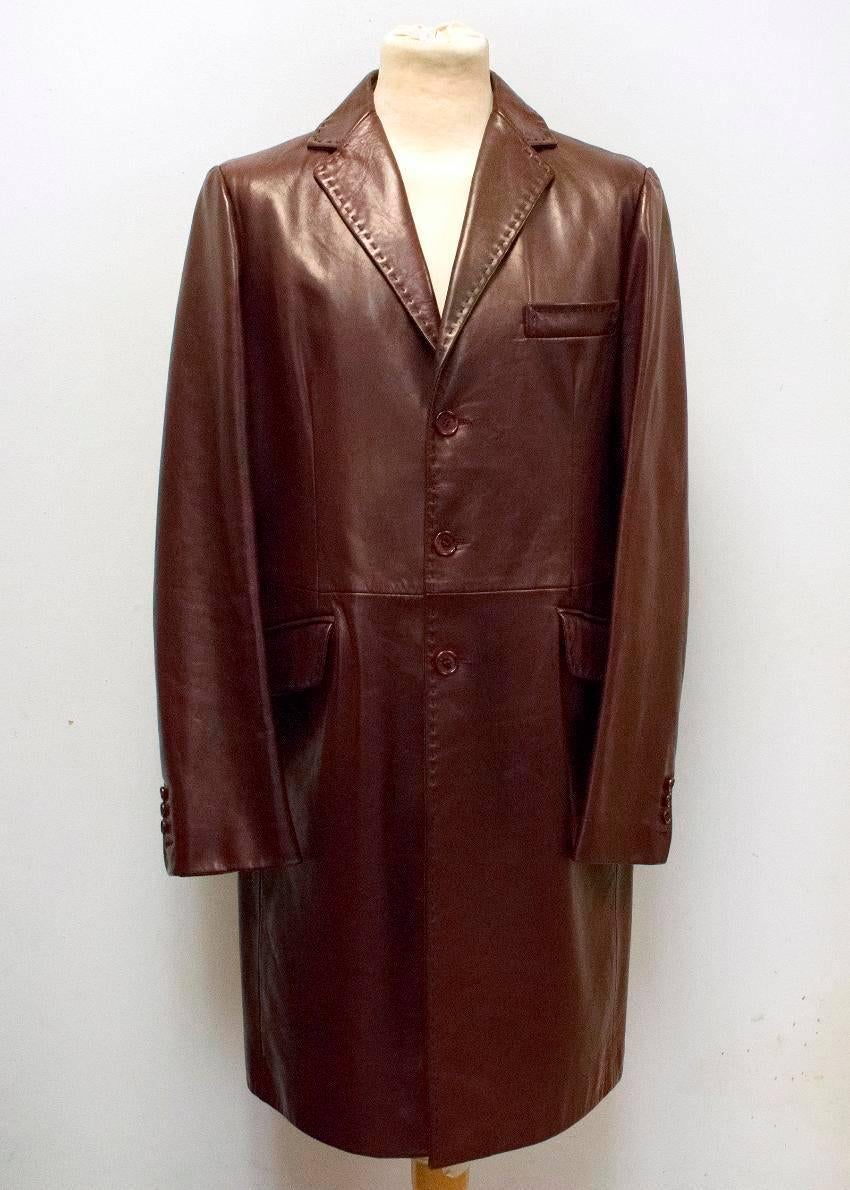 Dolce & Gabbana burgundy leather long coat. Featuring a single breasted notch lapel with three burgundy buttons down the placket. There is a pocket on the left chest and two side pockets by the waist. Vent at the back and lined on the inside.