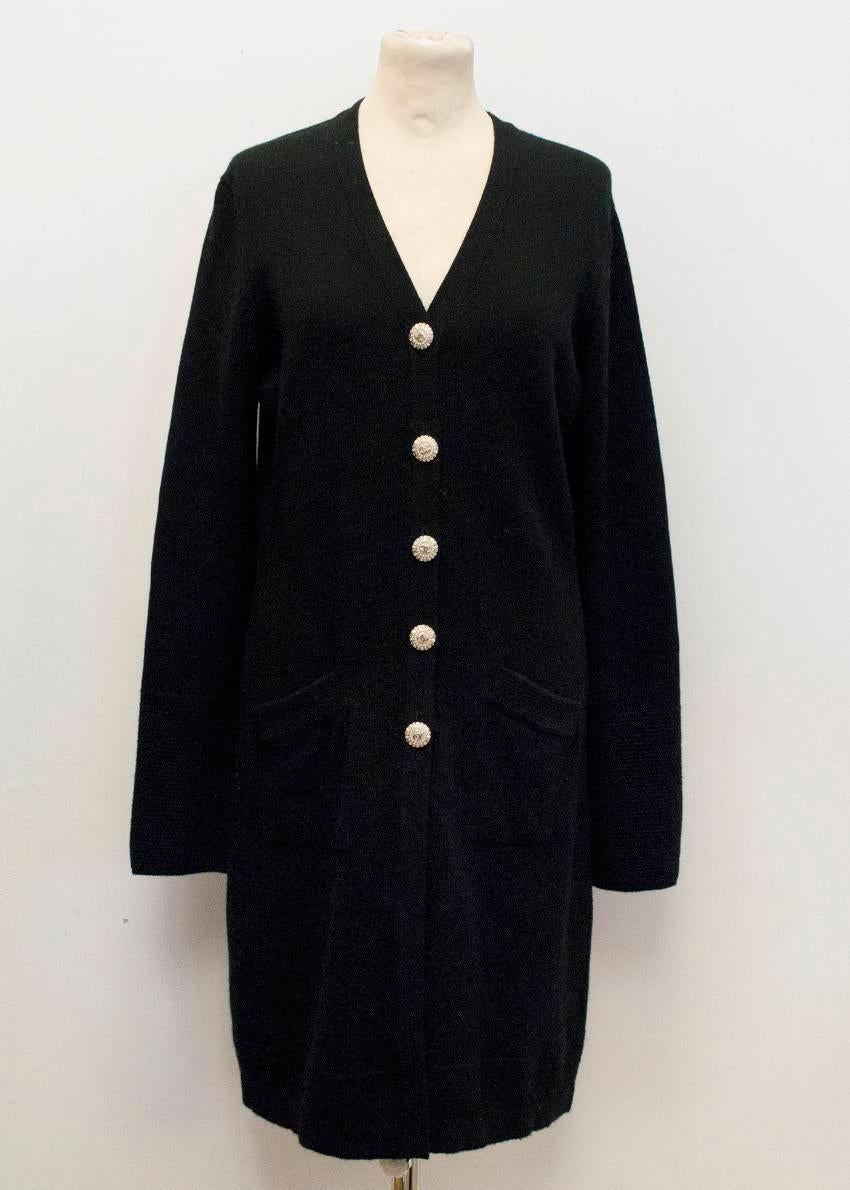 Chanel long black cashmere cardigan with gold buttons featuring the Chanel logo, pearls and diamantes. Soft to the touch. Full length sleeves with waffle stitch cuffs and hem. Please note there is a small snag at the back.
Great condition