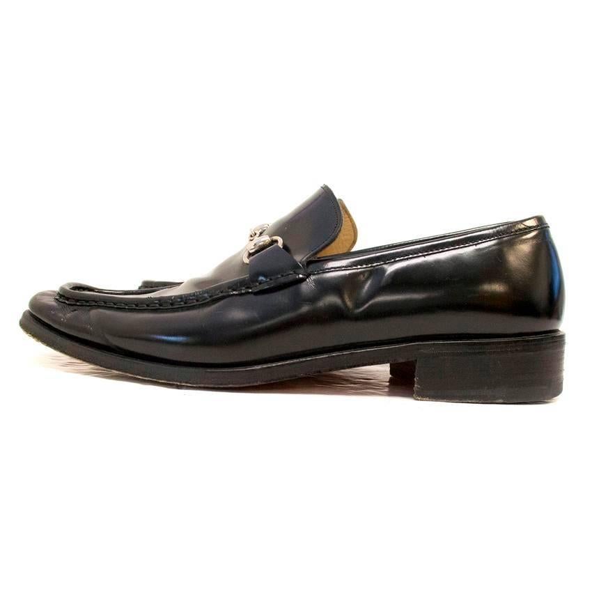 Gucci black leather loafers with a slight shine. They feature a silver metal buckle and a black wooden heel and midsole. 

The leather is slightly creased with a couple of very small scuffs, and the soles are worn. 

Condition: 9/10 

Please note