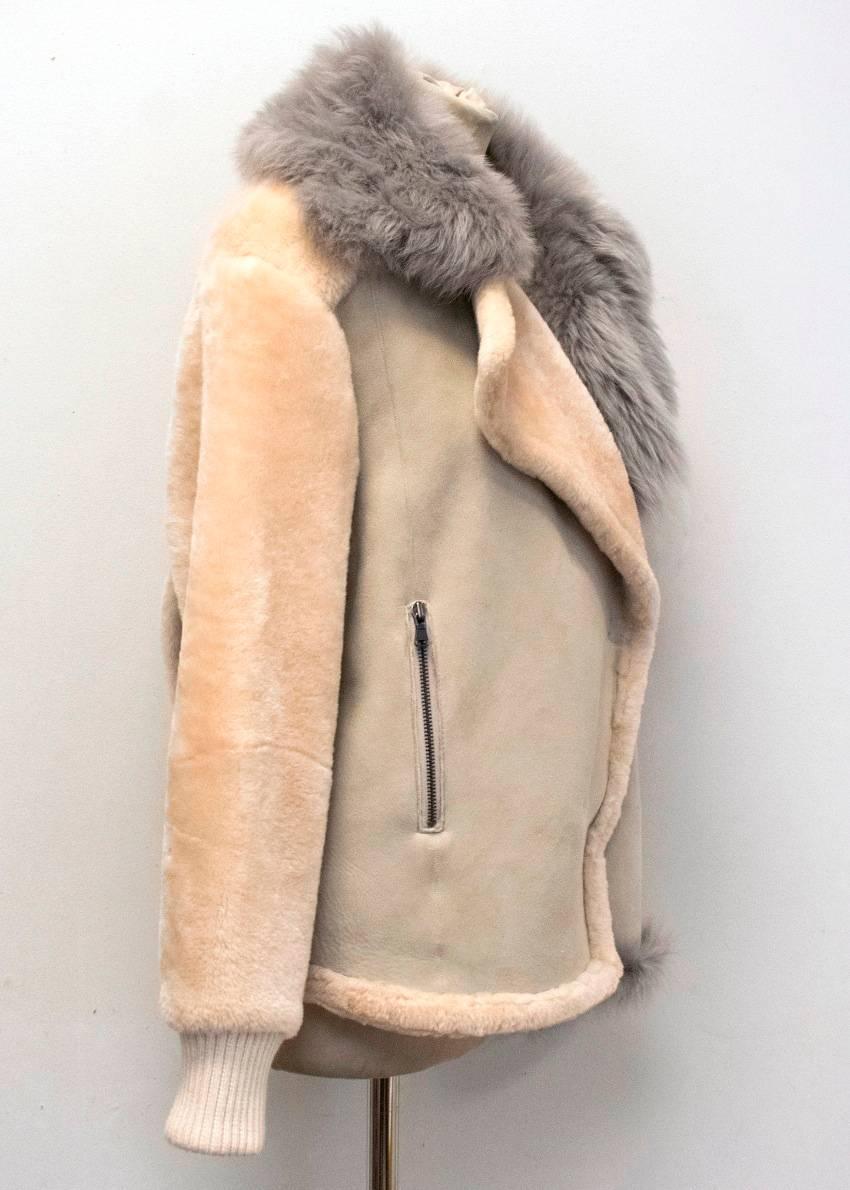 Tibi sheep skin and shearling, single breasted, three-buttoned jacket with grey fur collar. The jacket features two zip pockets at the front and fasteners at the collar.

9,5/10
The jacket has a minor mark on the back at the bottom (please see
