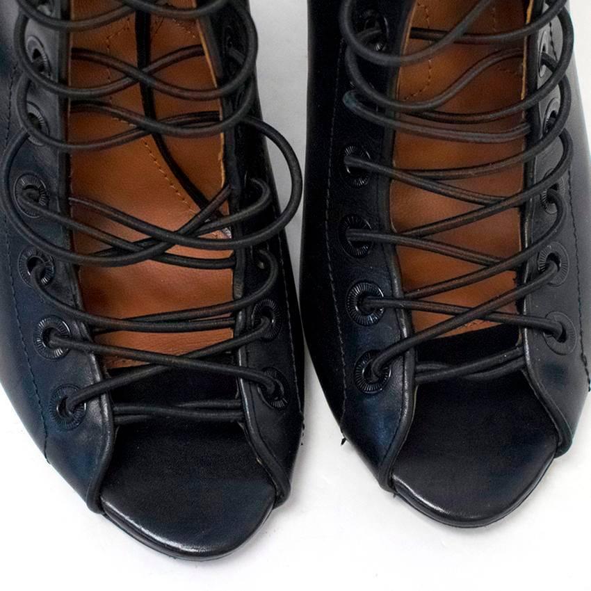 Givenchy black leather peep toe boots on a leather wedge featuring elasticated lacing fitted through metal eyelets at the front. Fasten on the side with a black zip. 
Made in Italy.

There is minor wear to the soles and some marks to the exterior