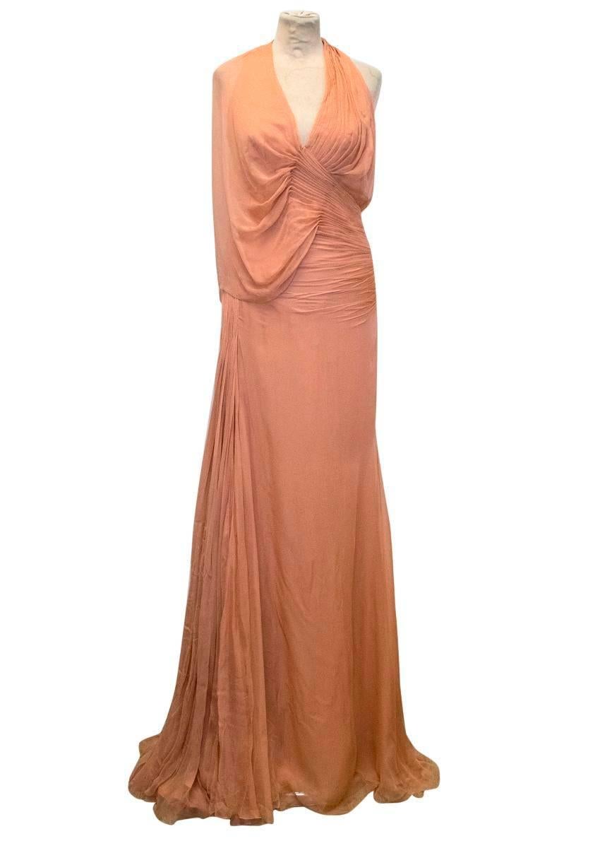 Atelier Versace blush ruched gown. This gown has a v-cut with ruched detailing on the chest and around the waist. There is a loose fabric that drapes down the right arm. The bottom half of the gown is loose. This dress is fully lined and features an